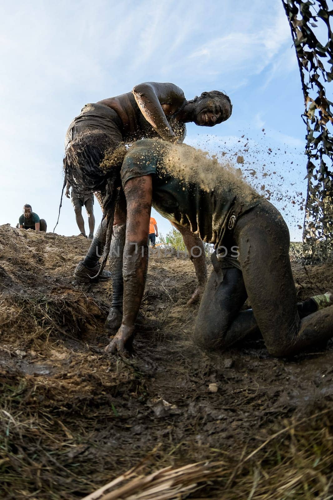 ESTARREJA, PORTUGAL - SEPTEMBER 23: Athletes crawling through mud at the Biorace on september 23, 2017 in Estarreja, Portugal.