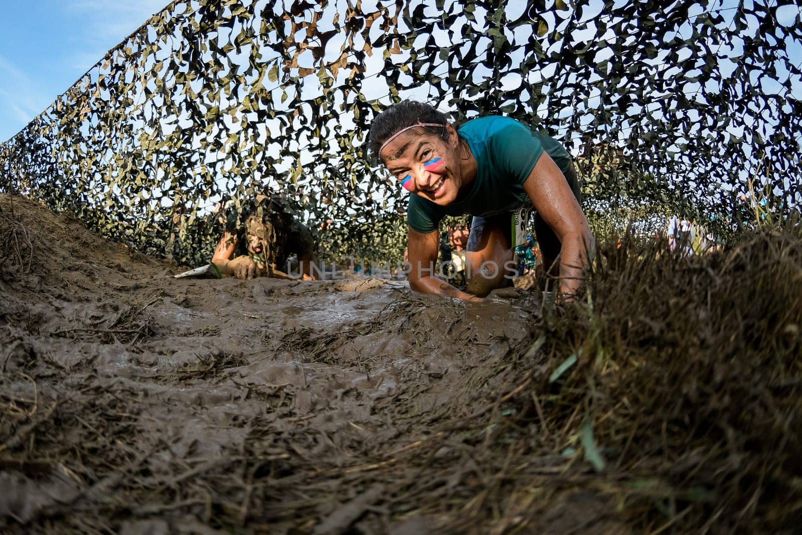 ESTARREJA, PORTUGAL - SEPTEMBER 23: Athletes crawling through mud at the Biorace on september 23, 2017 in Estarreja, Portugal.