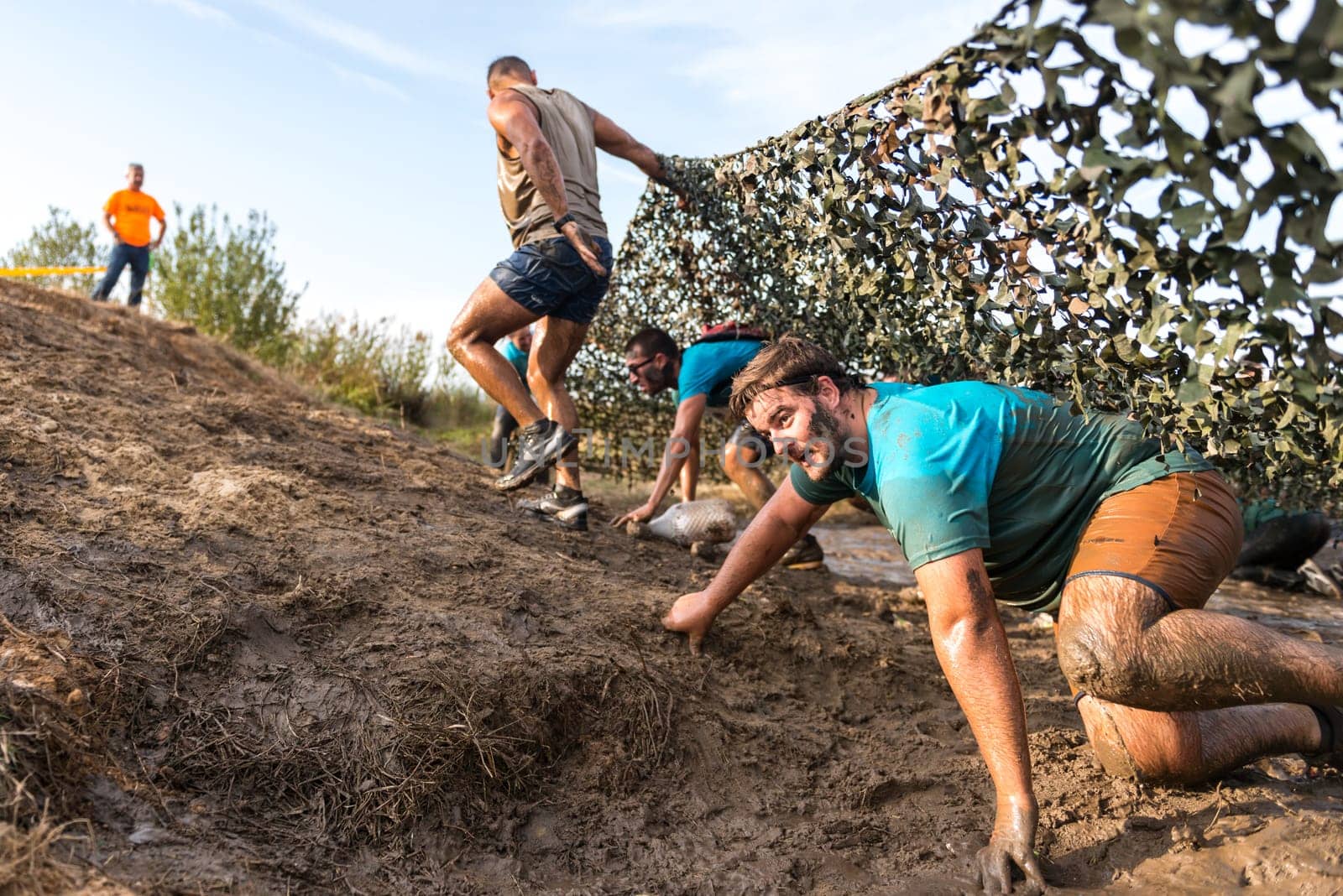 ESTARREJA, PORTUGAL - SEPTEMBER 23: Athletes crawling through mud at the Biorace on september 23, 2017 in Estarreja, Portugal.