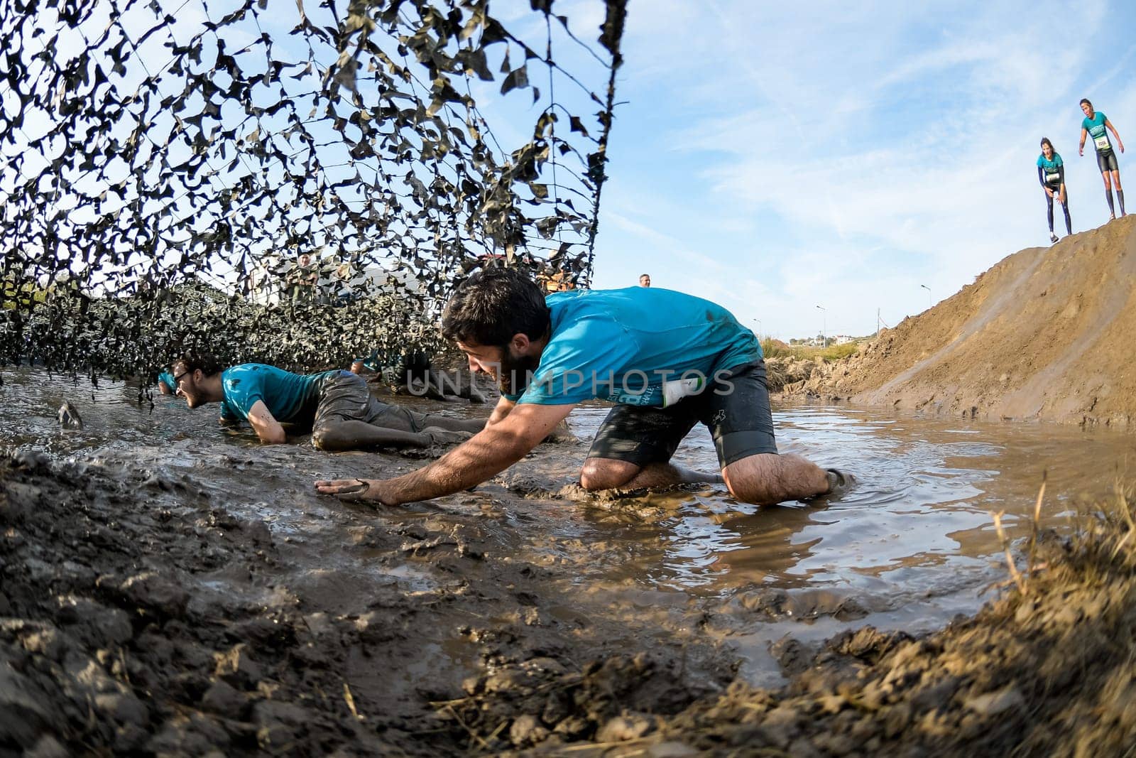 ESTARREJA, PORTUGAL - SEPTEMBER 23: Athletes crawling through mud at the Biorace on september 23, 2017 in Estarreja, Portugal.