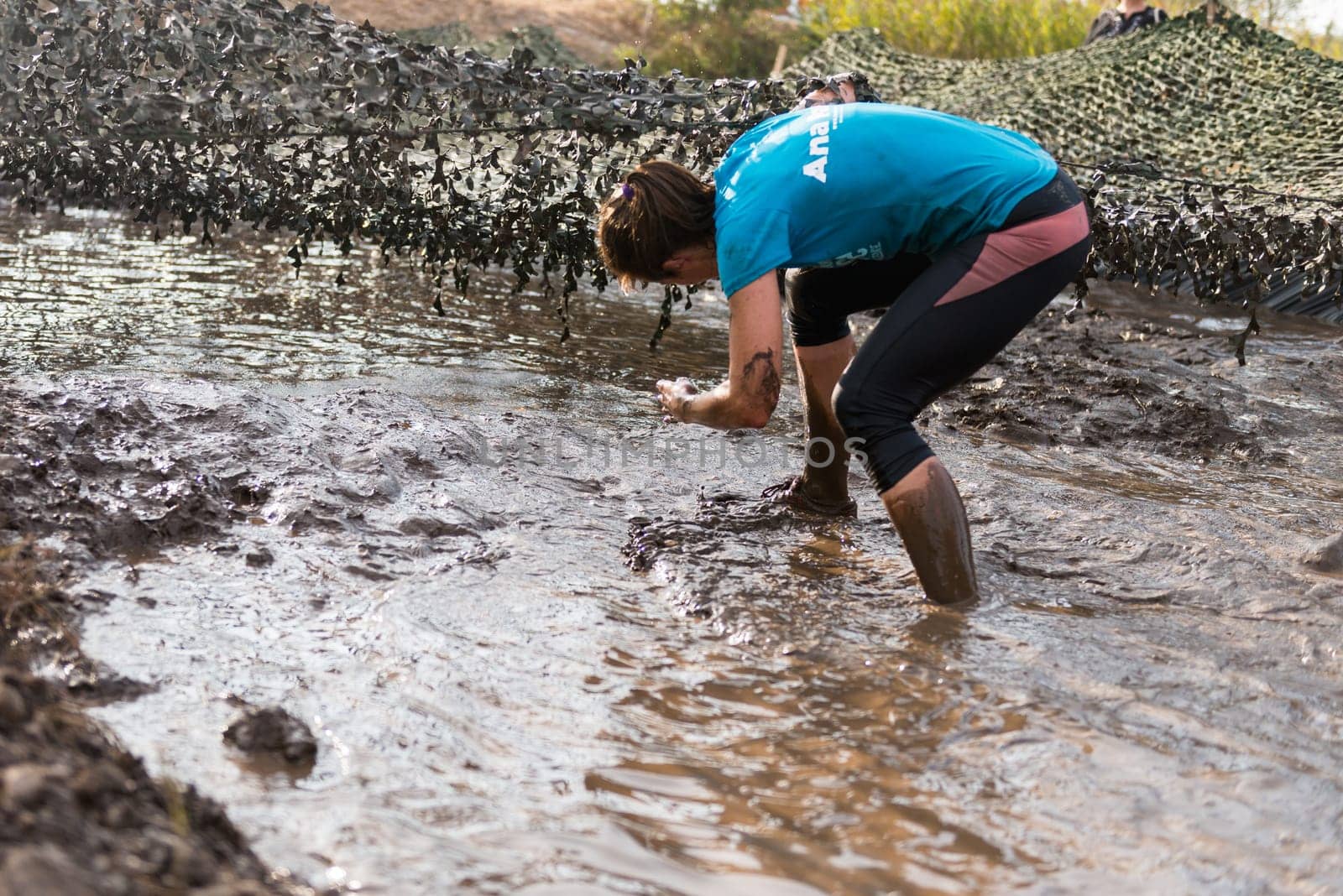 ESTARREJA, PORTUGAL - SEPTEMBER 23: Athletes crawling through mud at the Biorace on september 23, 2017 in Estarreja, Portugal.