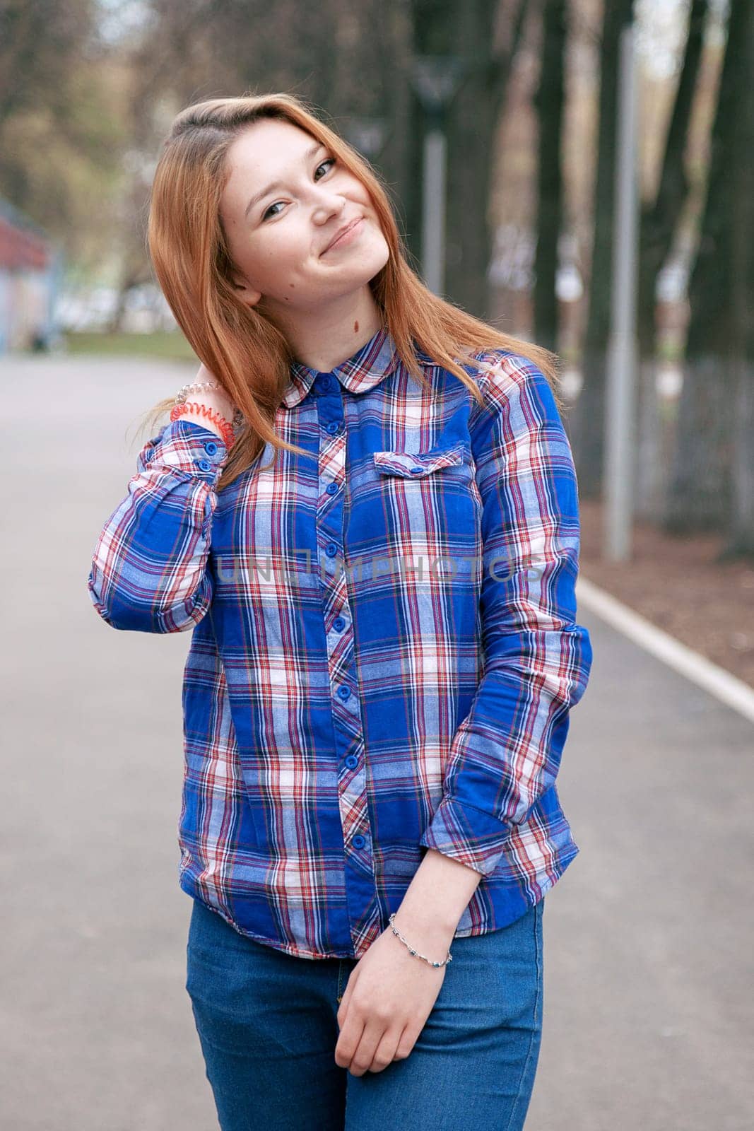 Portrait of a beautiful girl. smiling, posing on camera. in a blue shirt in a cage. On the background Wooden grid grid.