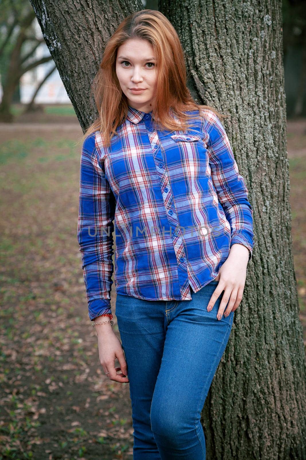 Portrait of a beautiful girl. smiling, posing on camera. in a blue shirt in a cage. On the background Wooden grid grid.