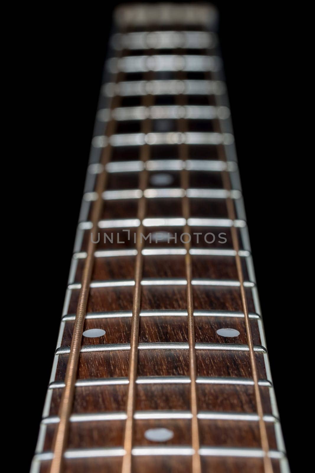 Acoustic  Bass Guitar Fretboard Close Up with black background.