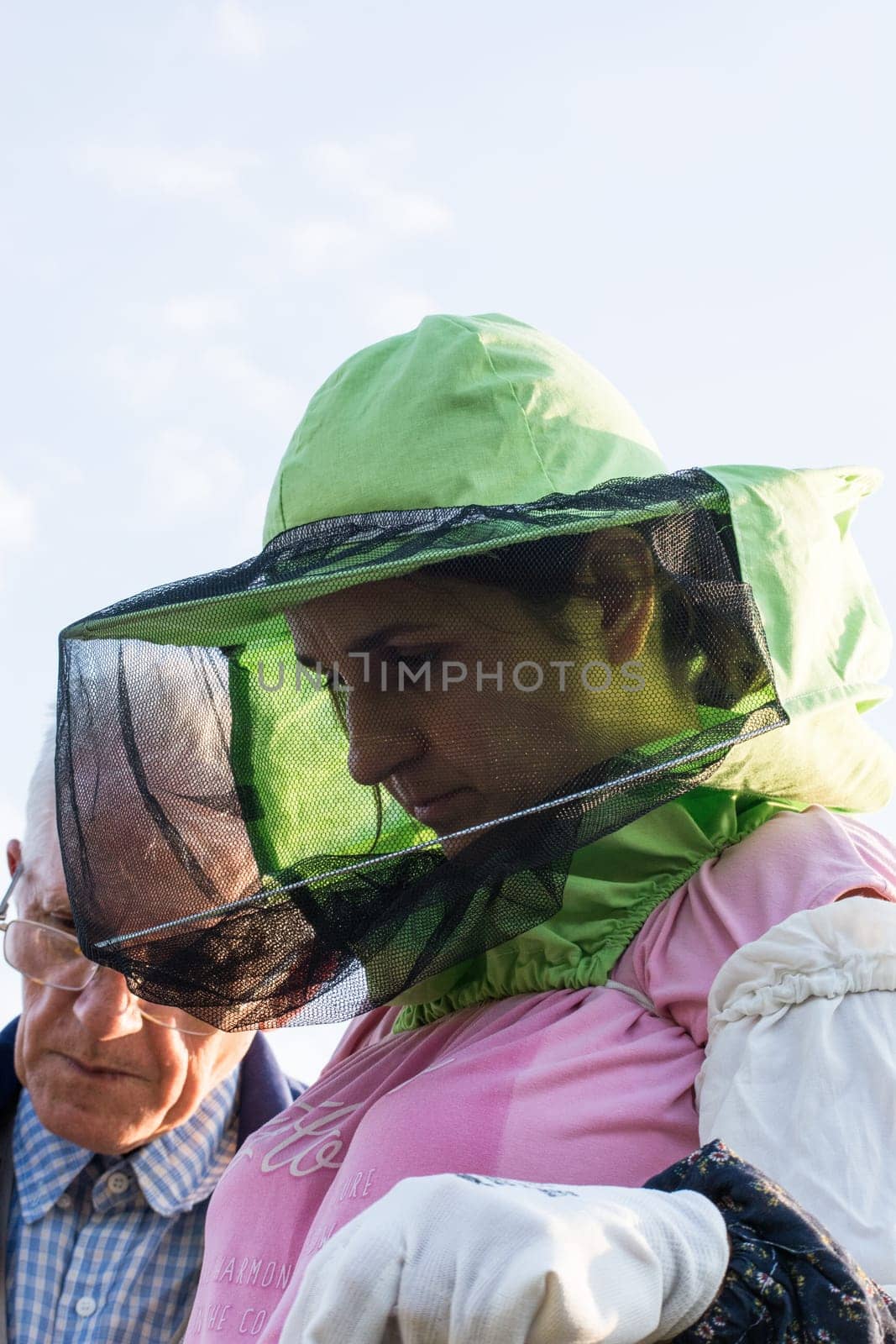 woman beekeeper looks after bees in the hive with senior beekeeper mentor
