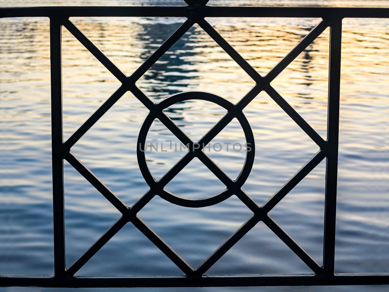 The shapes of a fence with water behind