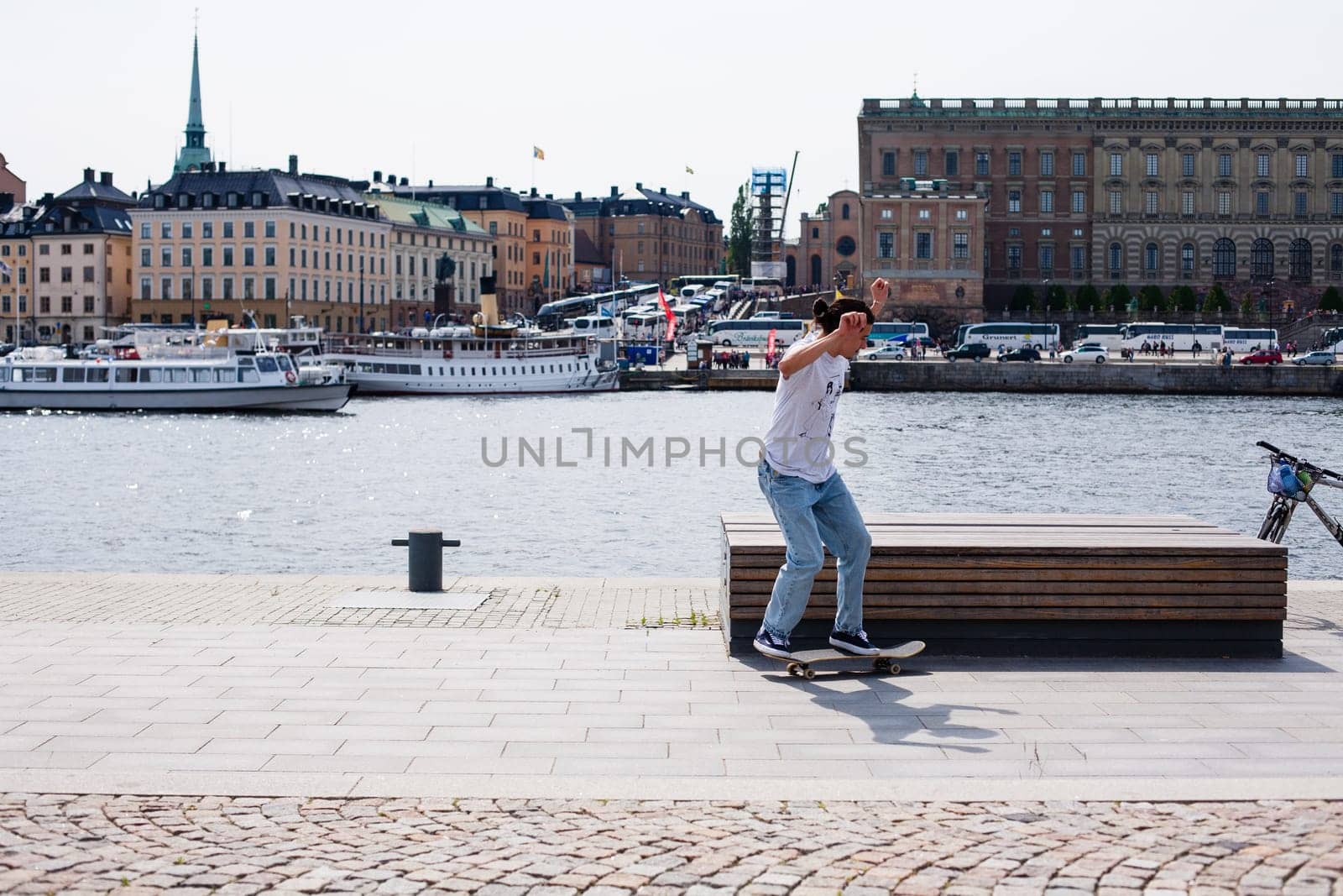 Stockholm, Sweden - June 10, 2017 : Urban life. Cool skateboarder outdoors Scandinavian guy performing a trick with his skate on the street