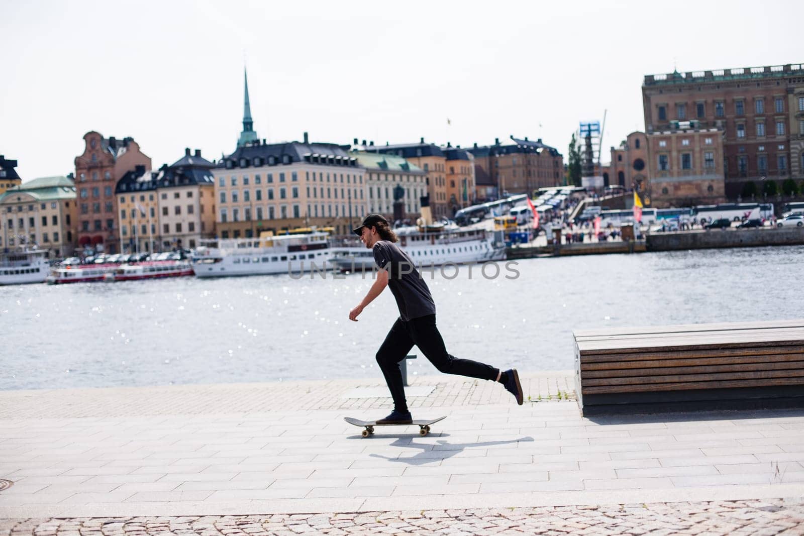 Stockholm, Sweden - June 10, 2017 : Urban life. Cool skateboarder outdoors Scandinavian guy performing a trick with his skate on the street