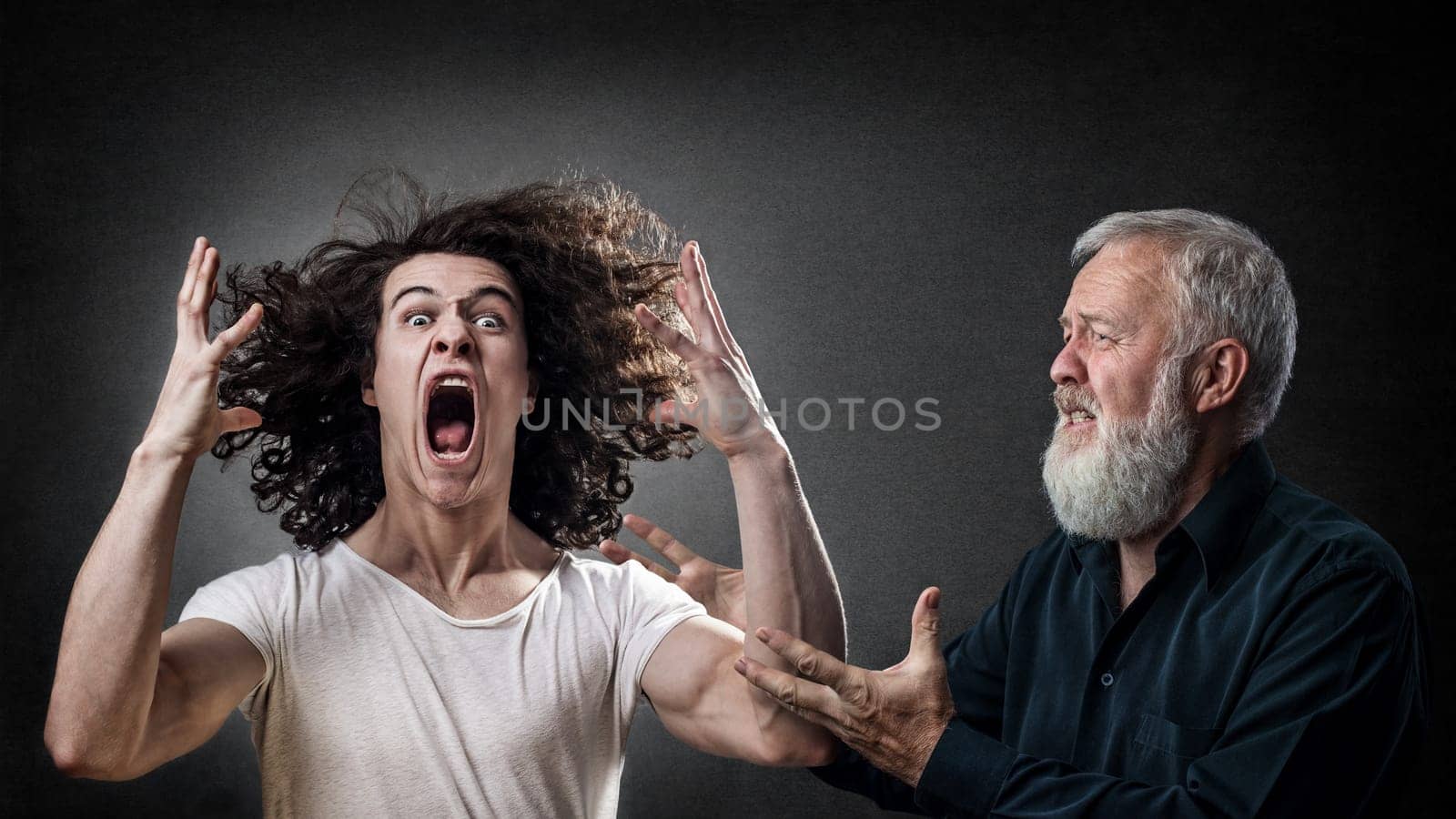 Senior looking to calm down an angry young man, son, student. Concept for angry prodigal son.