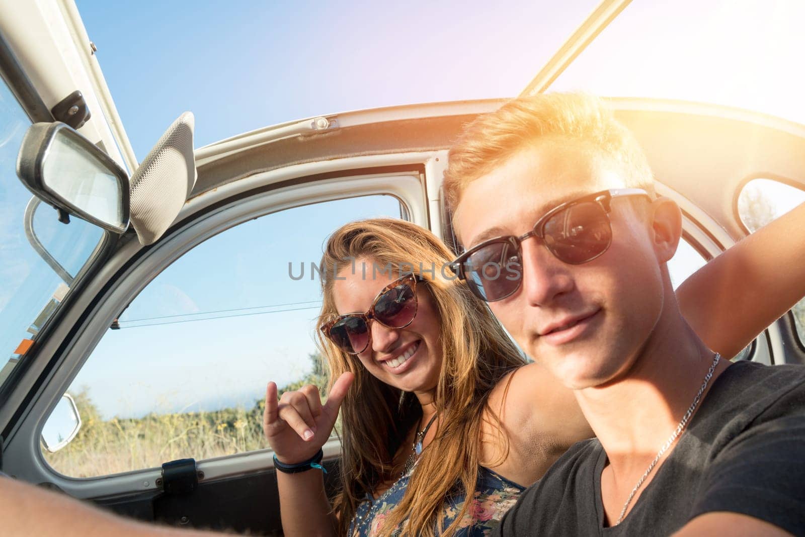 Young couple in a retro car at sunset, retro style.