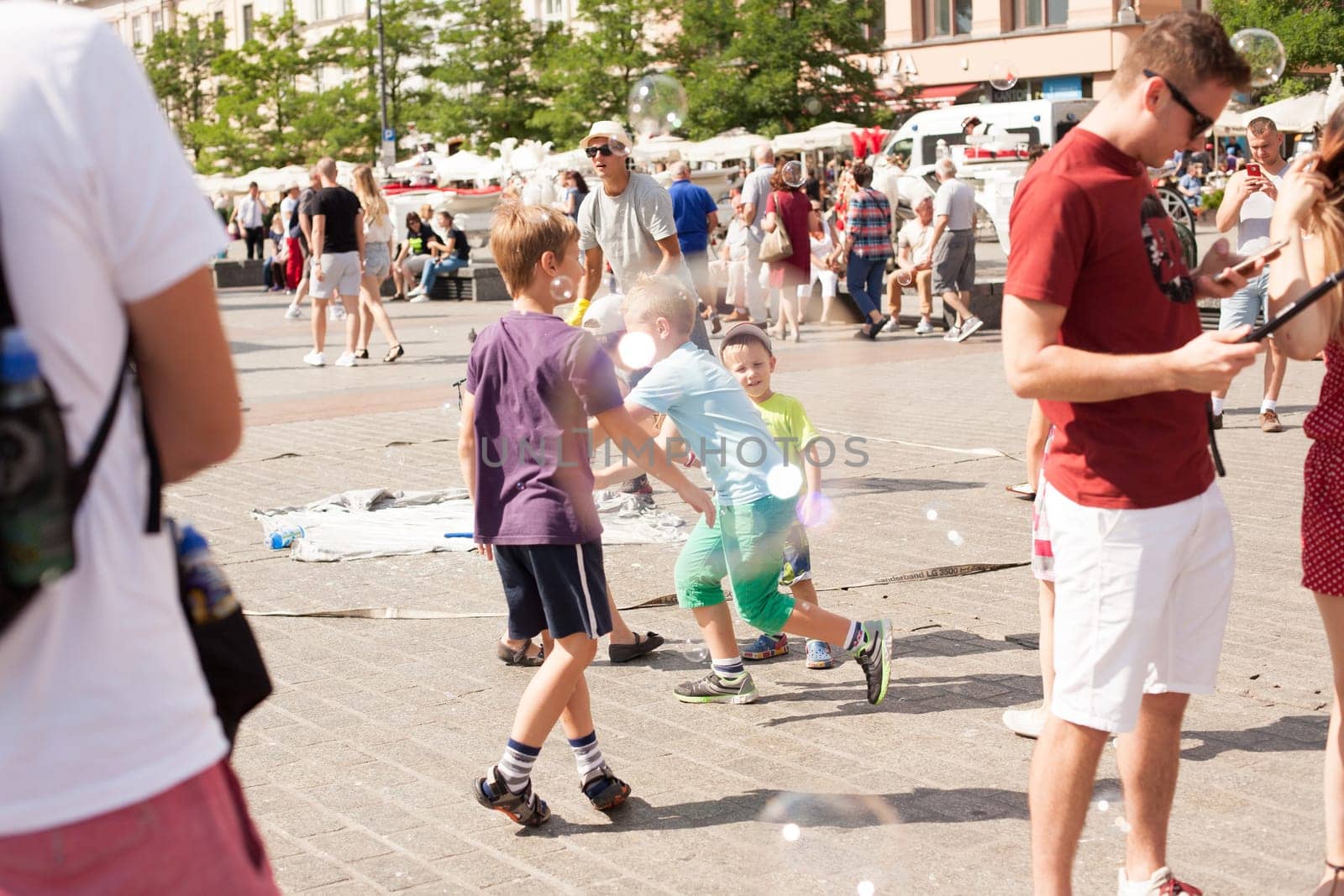 Krakow, Poland - July 29, 2017 : Children play with soap bubbles in the central square of old city. Urban life