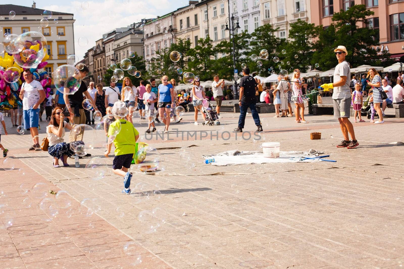Krakow, Poland - July 29, 2017 : Children play with soap bubbles in the central square of old city. Urban life
