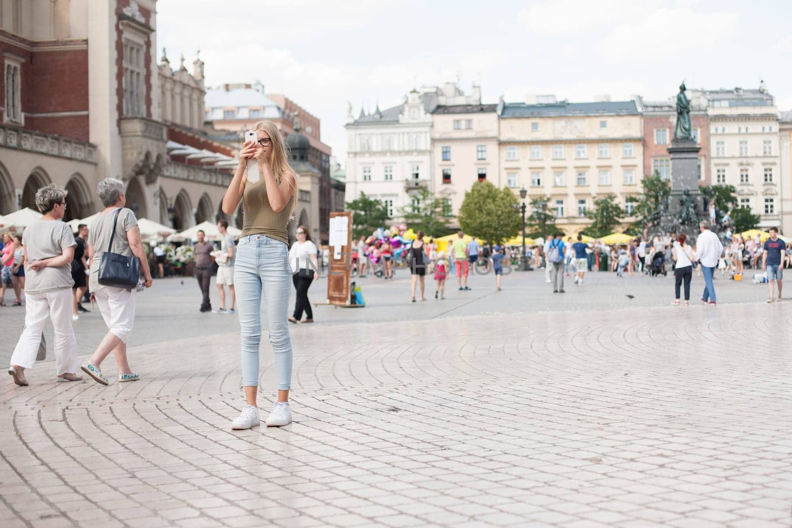 Krakow, Poland - July 29, 2017 : Tourist taking photos with his smartphone in historiccal center of city