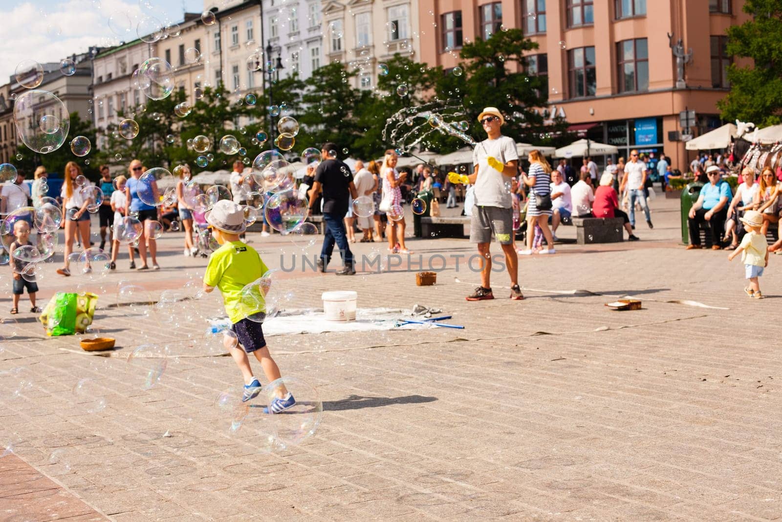 Krakow, Poland - July 29, 2017 : Children play with soap bubbles in the central square of old city. Urban life