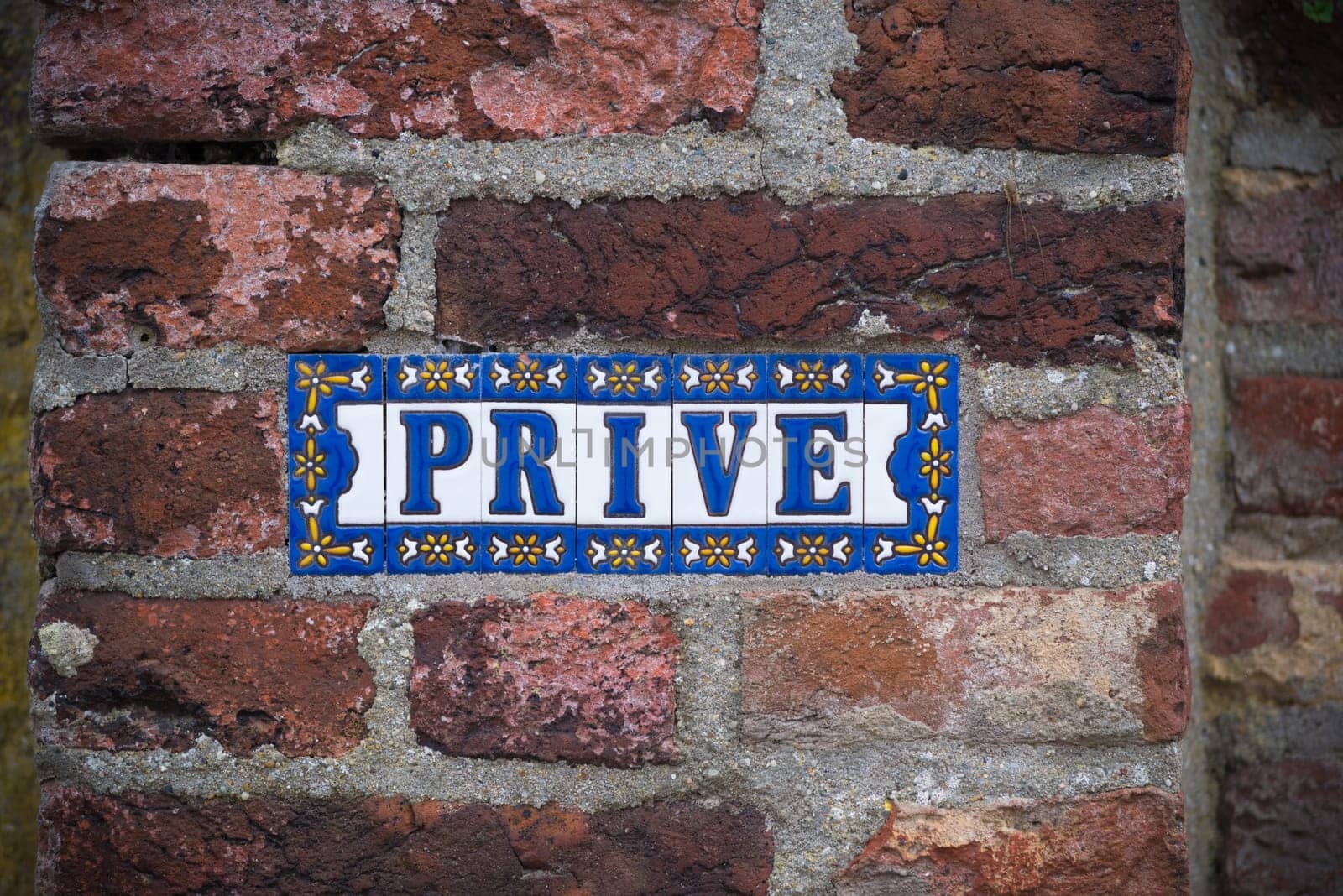 Prive (private in english) sign on a stone brick wall