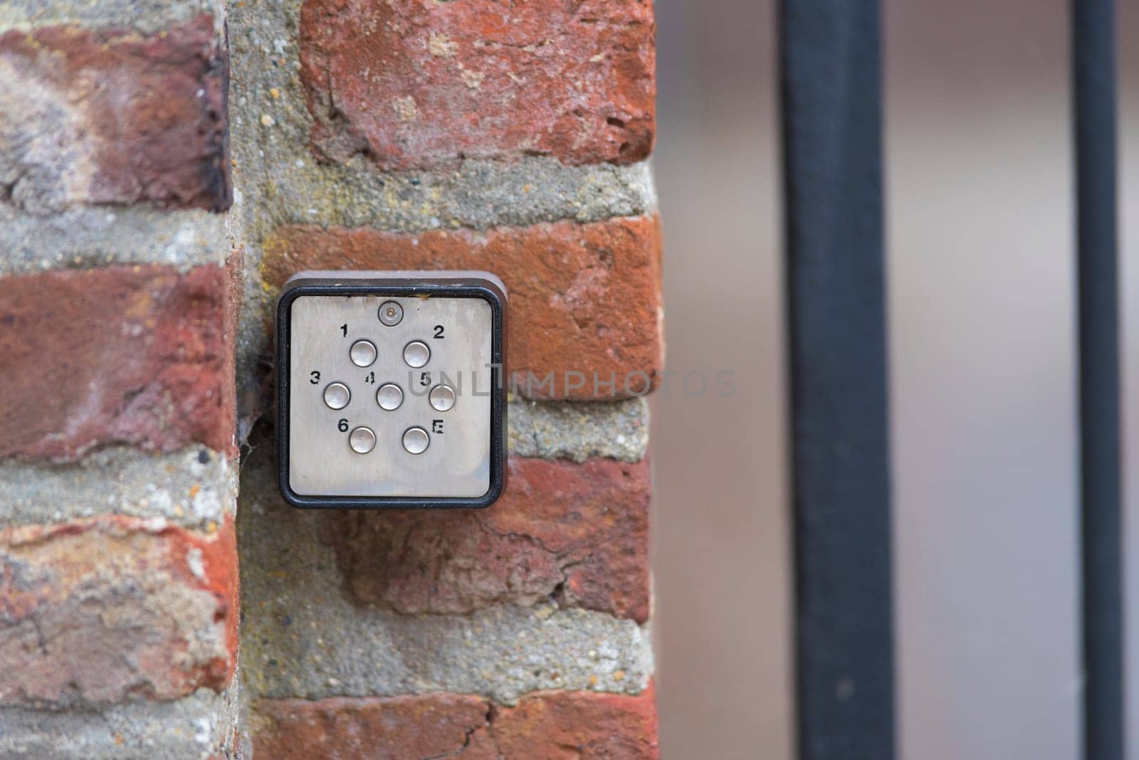 small door access controller on a red brick wall