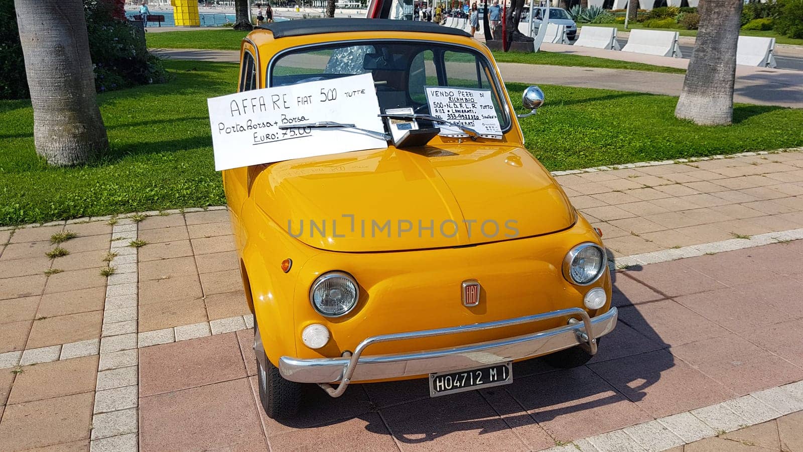 Menton, France - September 9, 2017: For Sale Sign on Windshield of Vintage Orange Fiat 500 Car Parked on the Esplanade Francis Palmero in the City of Menton .