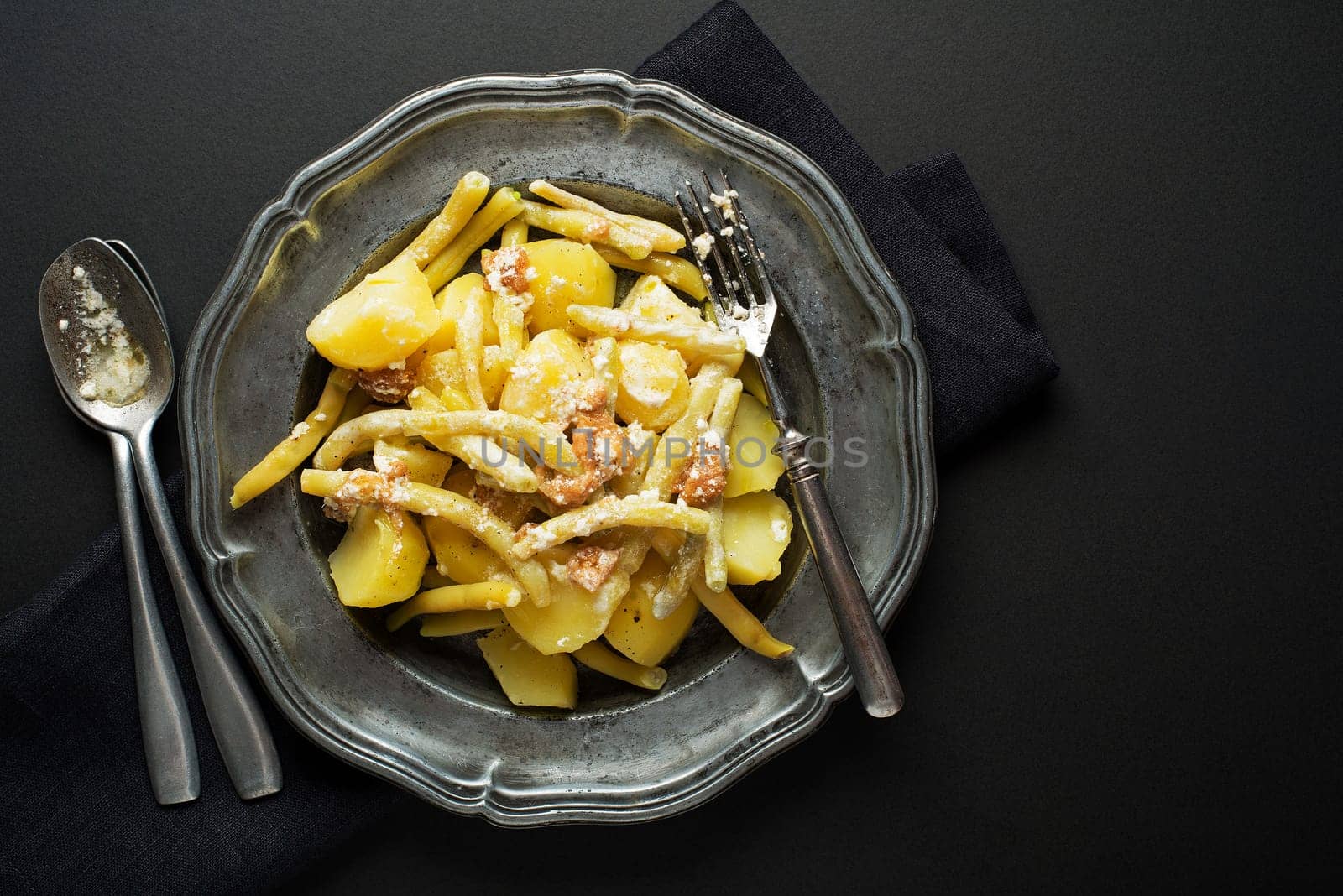 Traditional meal with green beans and potatoes dressing with lard