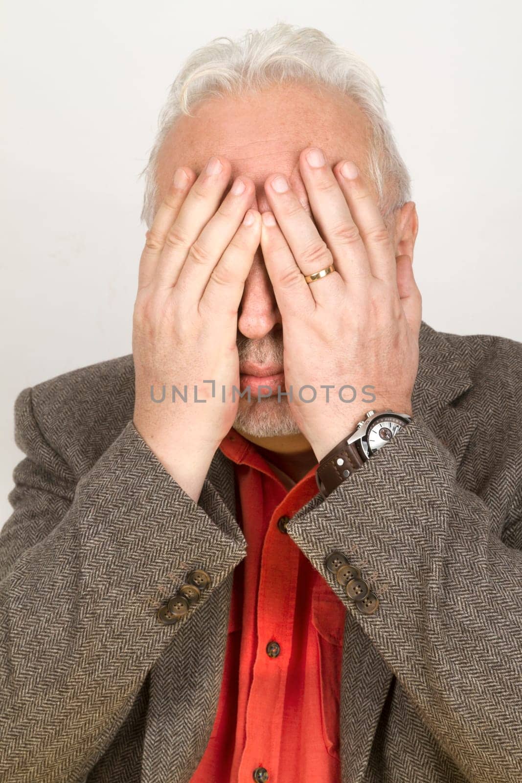 Senior holds his hands in front of his face