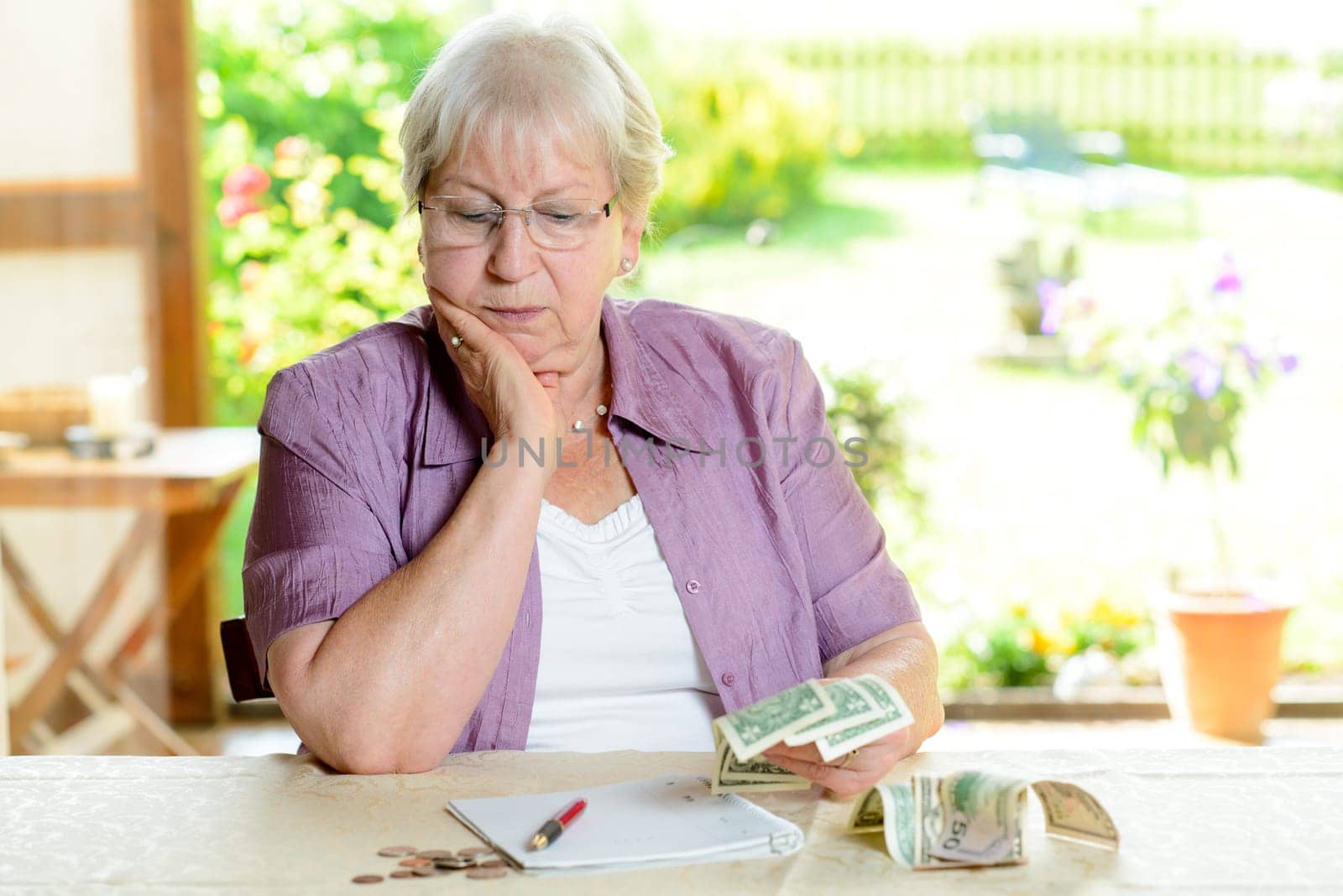 worried female senior is calculating her budget