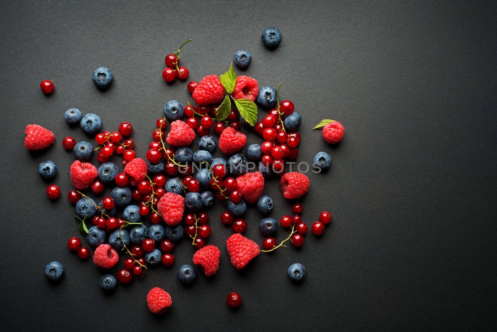 Bowl of fresh mixed berries on black background