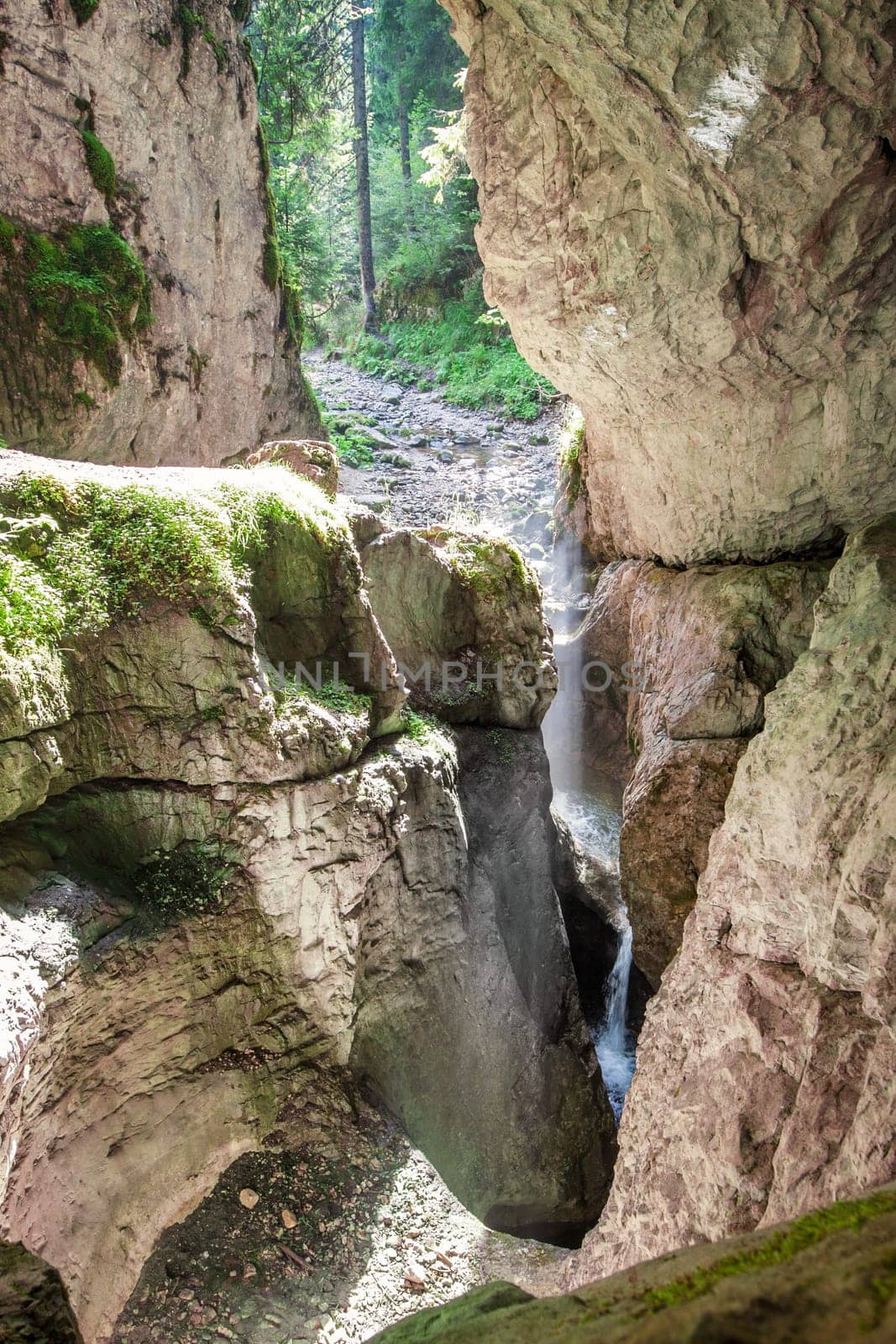 Entry with a stream in a mountain cave