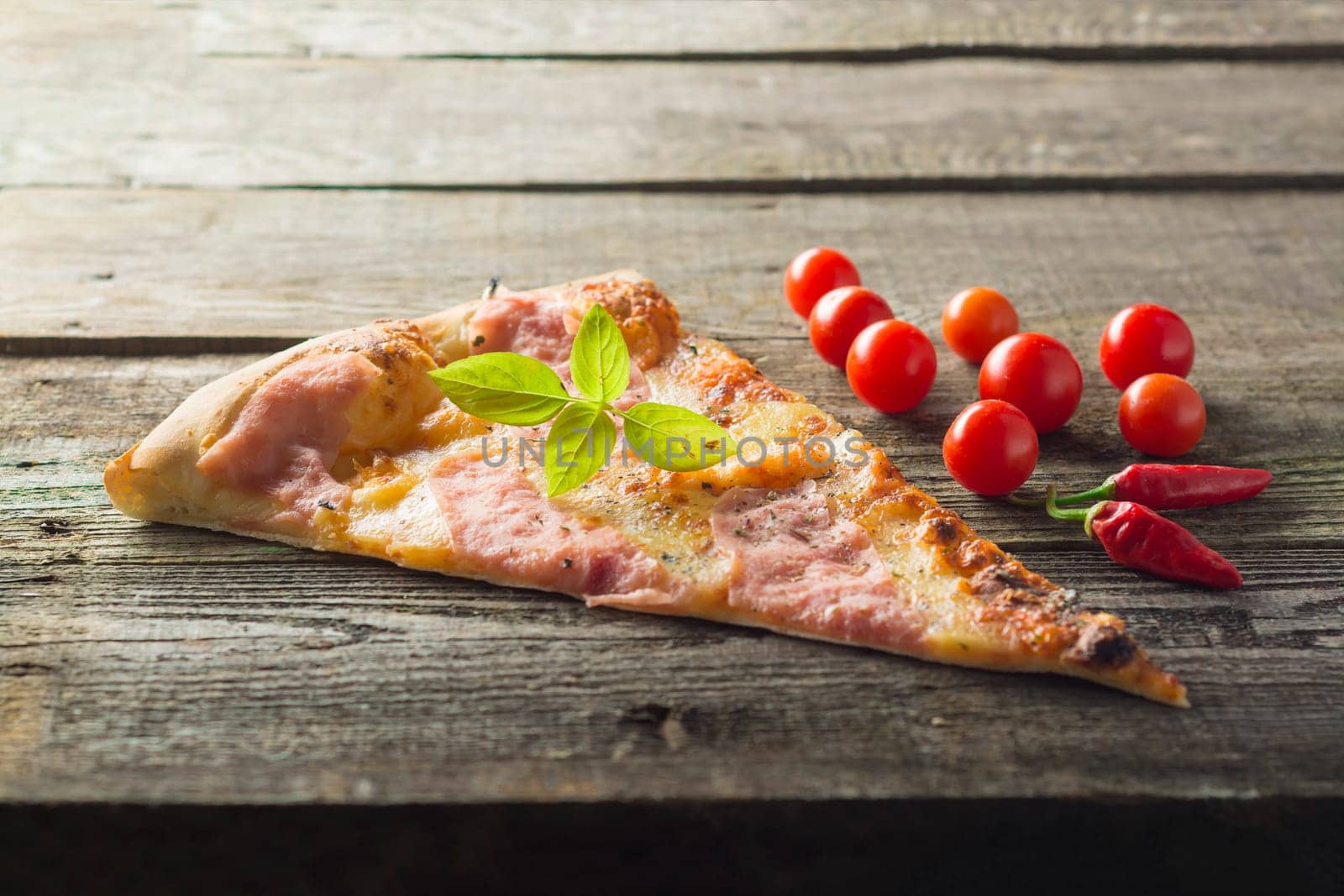 Italian food - pizza on wooden table. Cherry tomato and hot peppers
