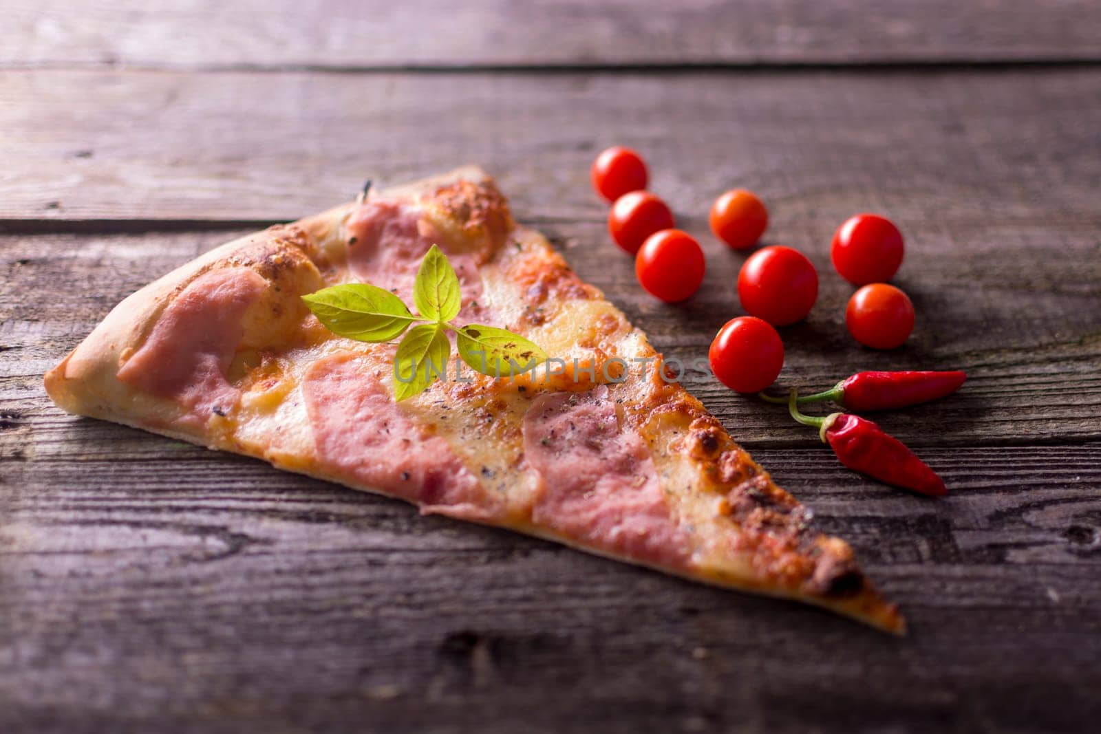 Italian food - pizza on wooden table. Cherry tomato and hot peppers