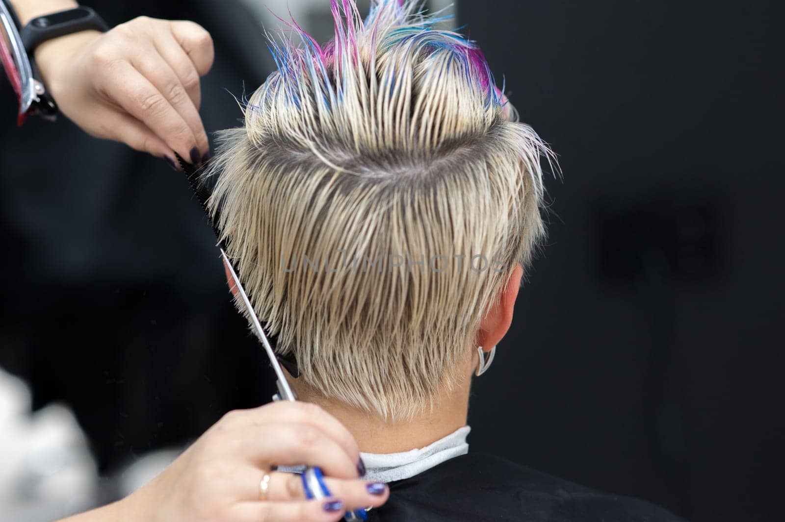 Women's haircut. Hairdresser, beauty salon. Professional hairdresser making stylish haircut. Hairdresser cutting woman bangs hair. Process of hair cutting with use scissors