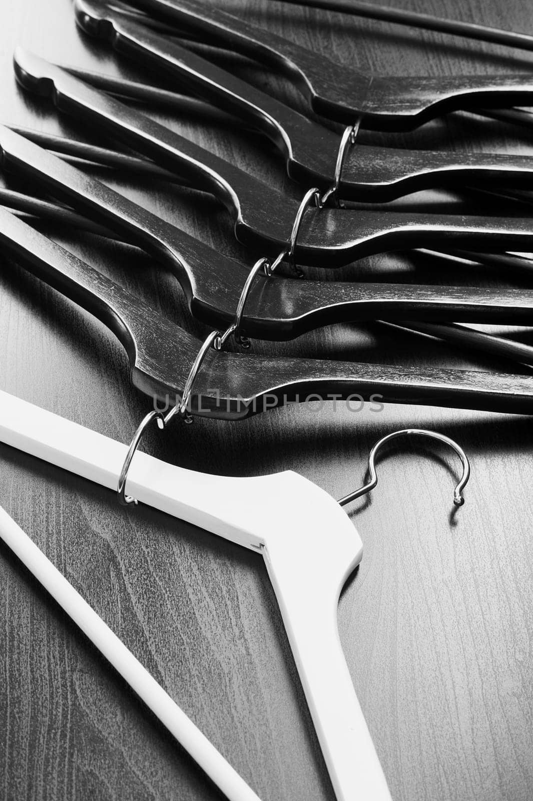 White hanger and a few black hangers, black background, abstract