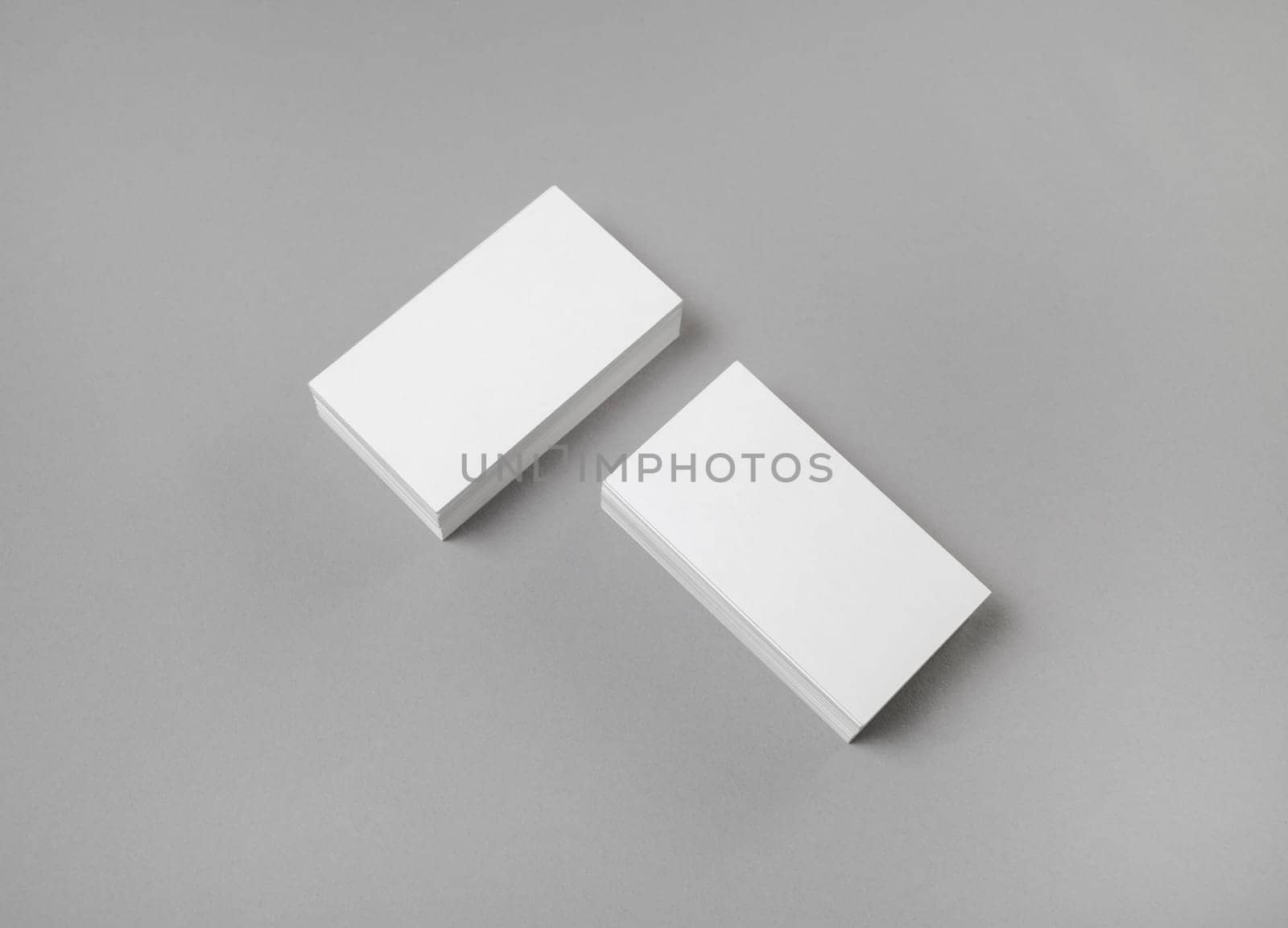 Photo of blank business cards on gray paper background. Template for ID. Mock-up for branding identity. Top view.