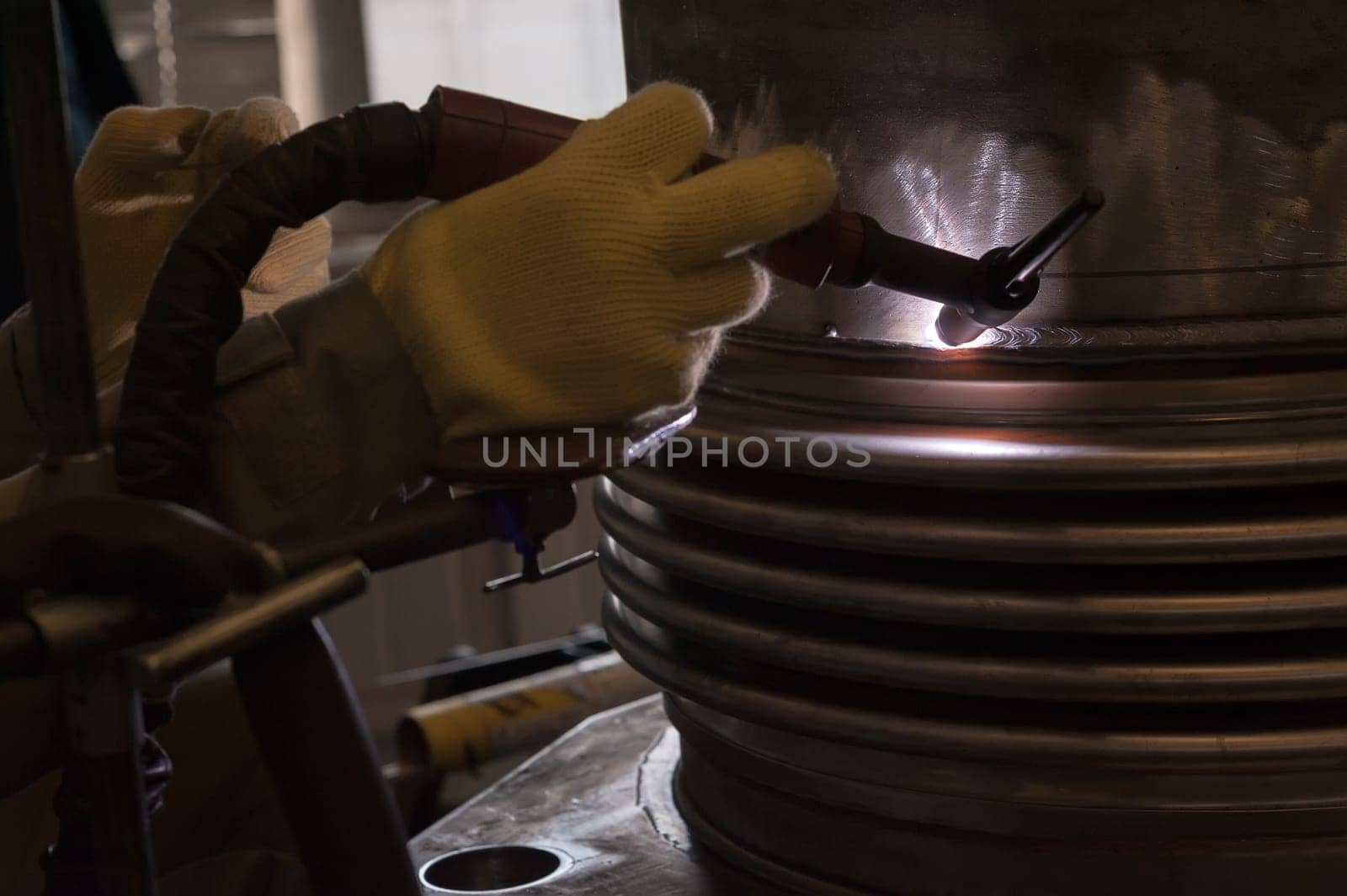 Welder with protective mask welding metal and sparks.