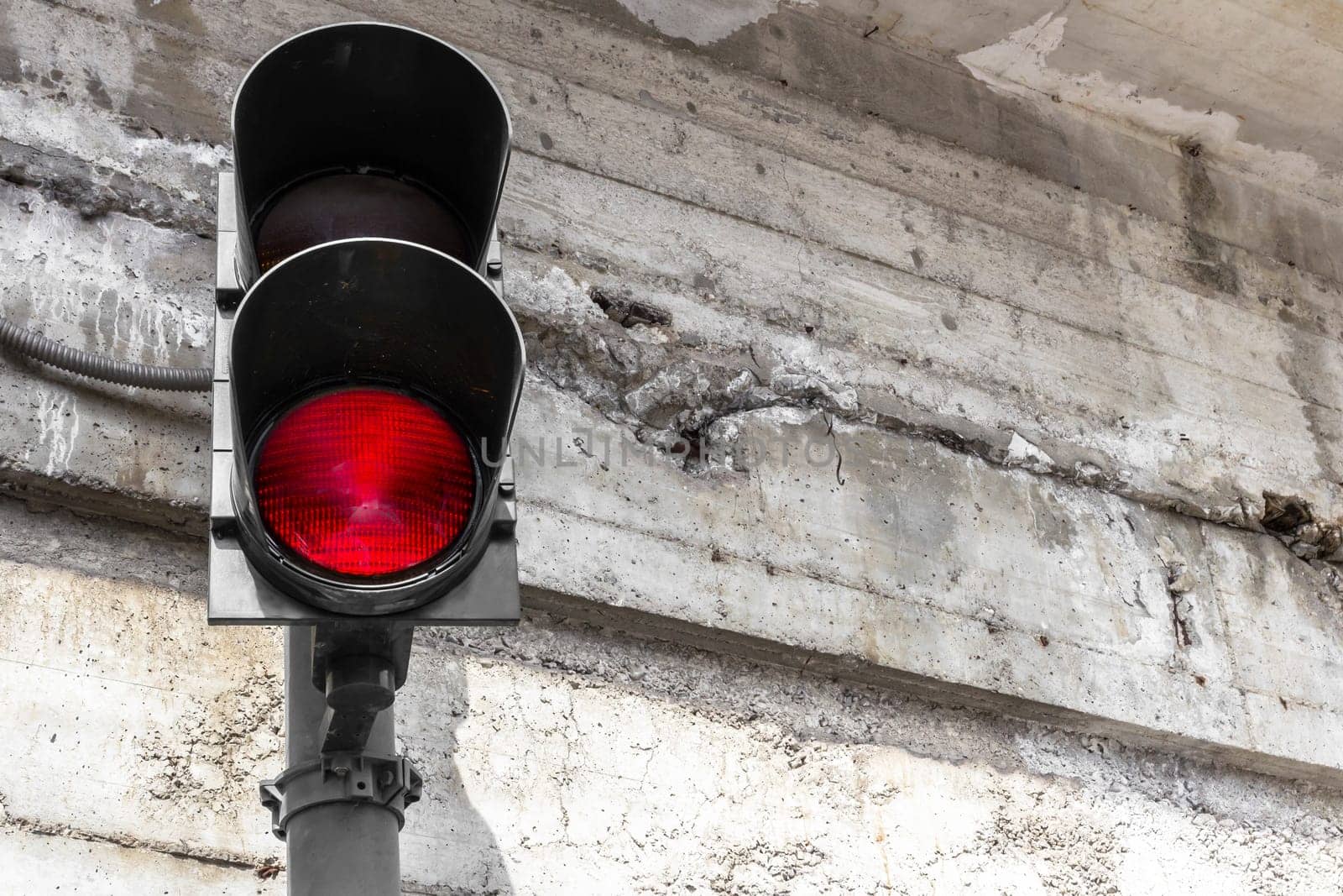Red street electric lamp on a grunge concrete wall with place for your text