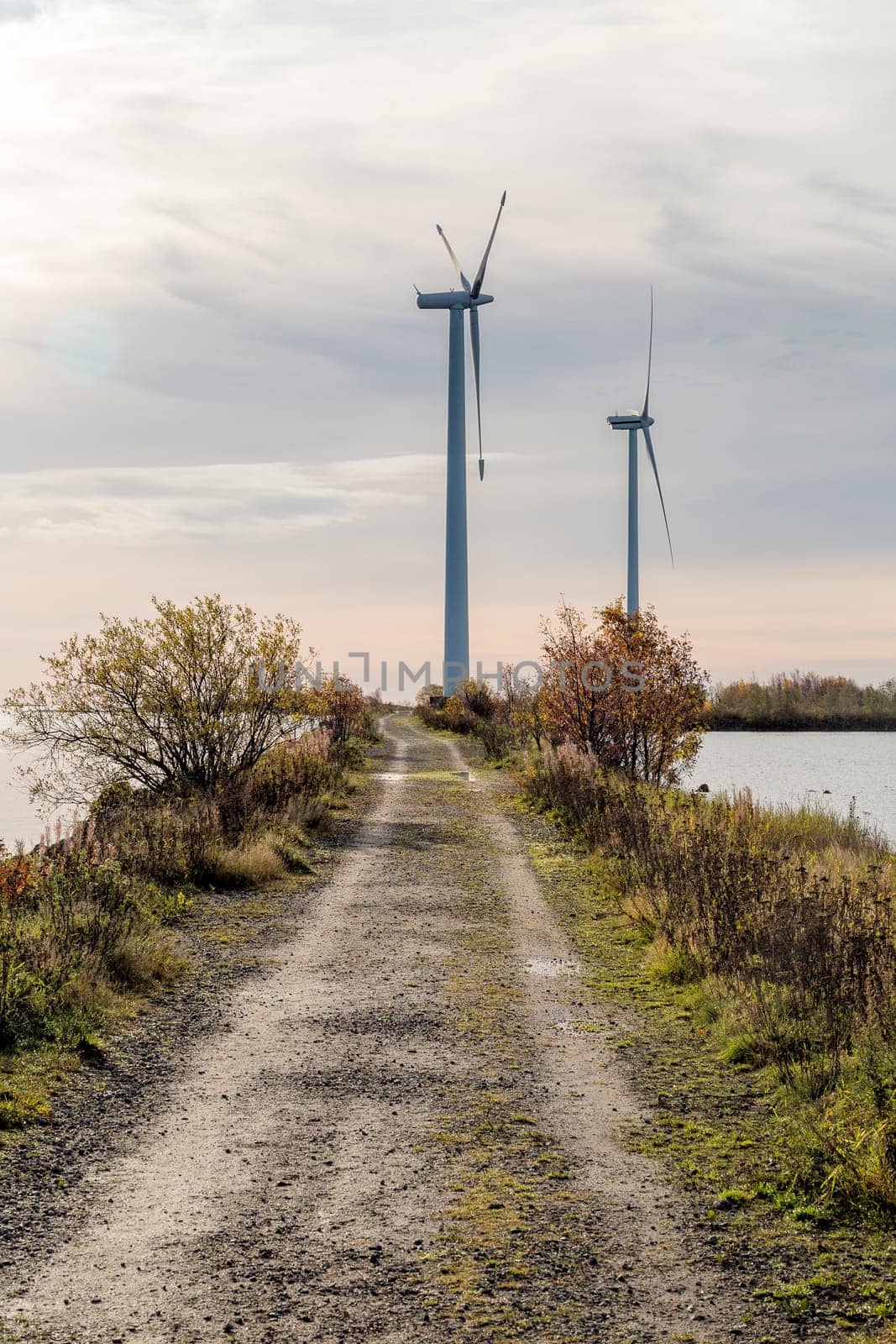 Wind Power Stations by Gravel Road and Ocean.