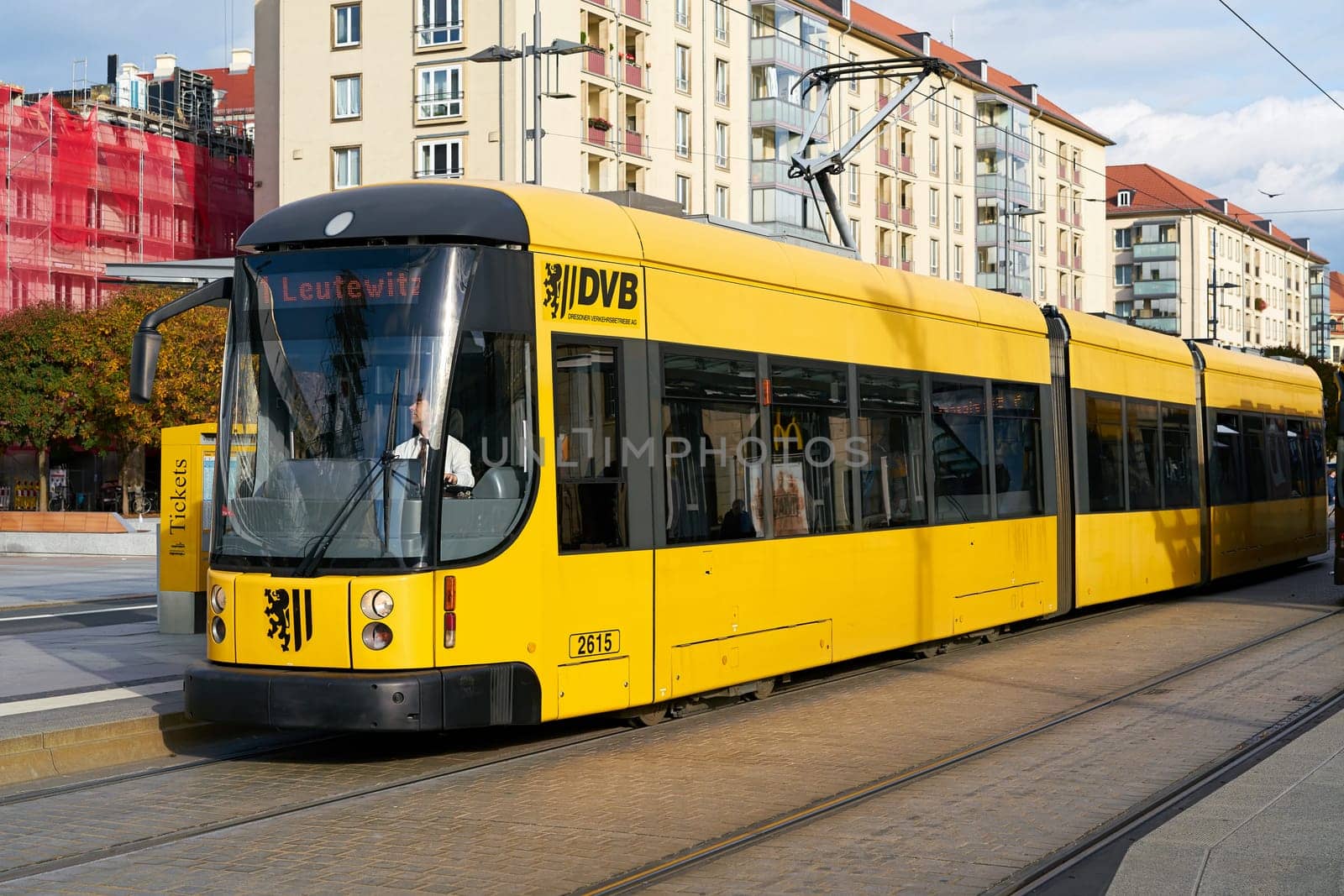 yellow tram at a stop in the city center of Dresden
