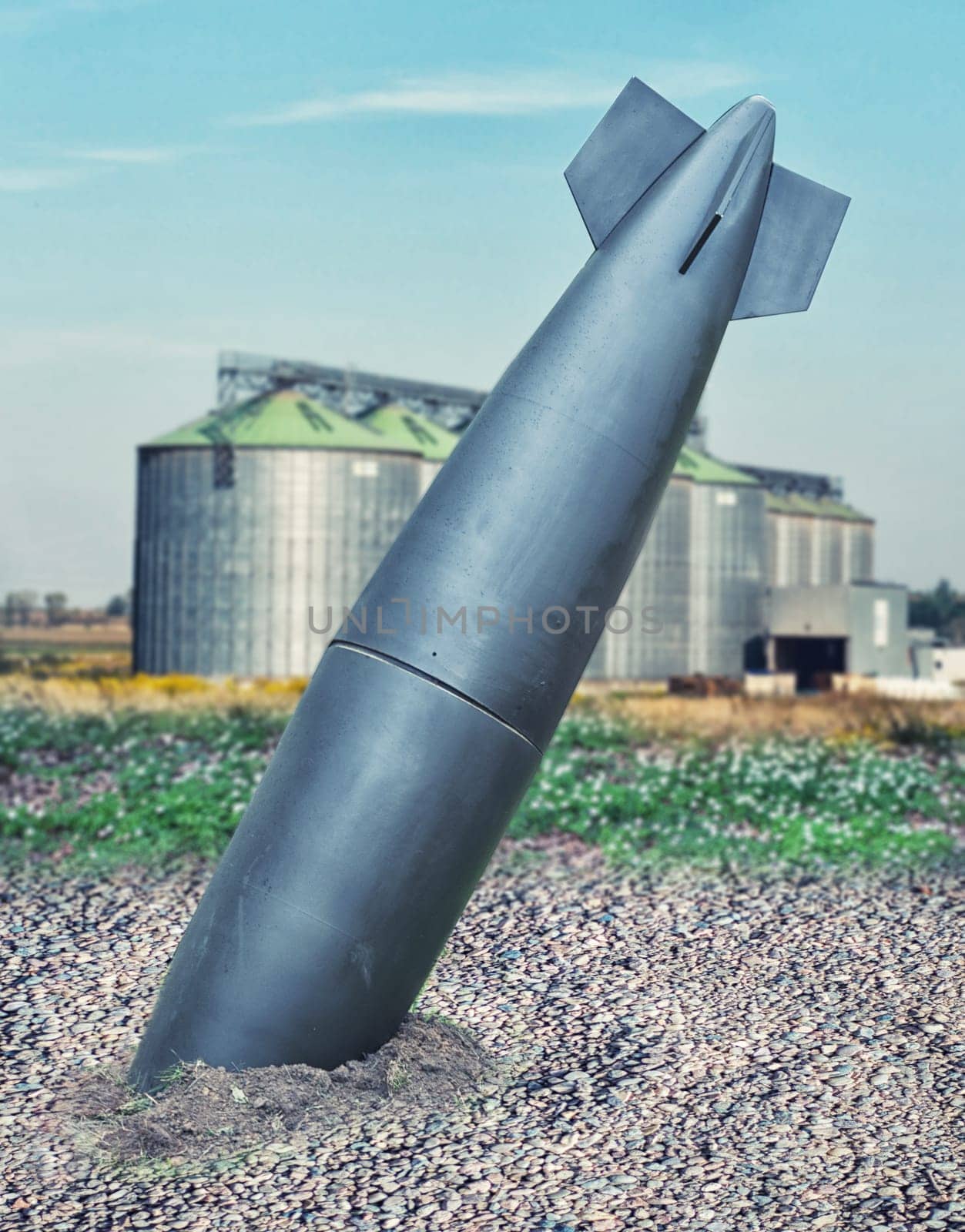 close up on misfire or unexploded bomb with the factory on background