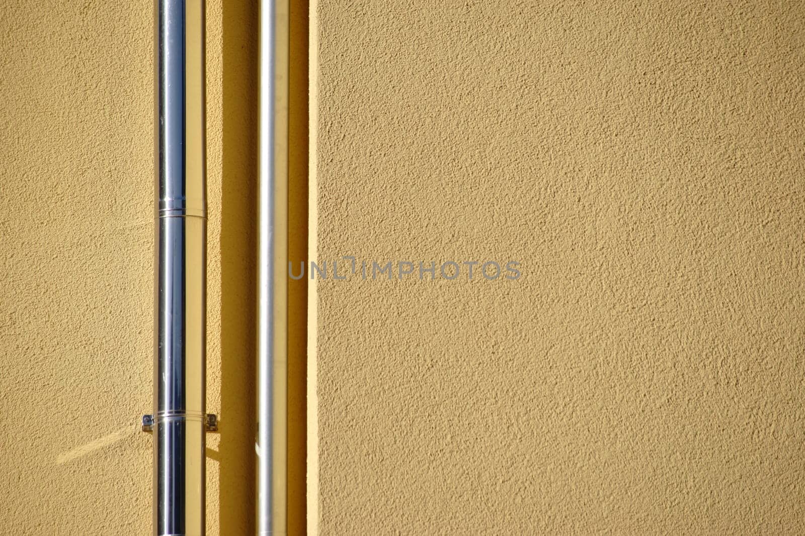 The close-up of newly laid stainless steel rain pipes on a new façade.