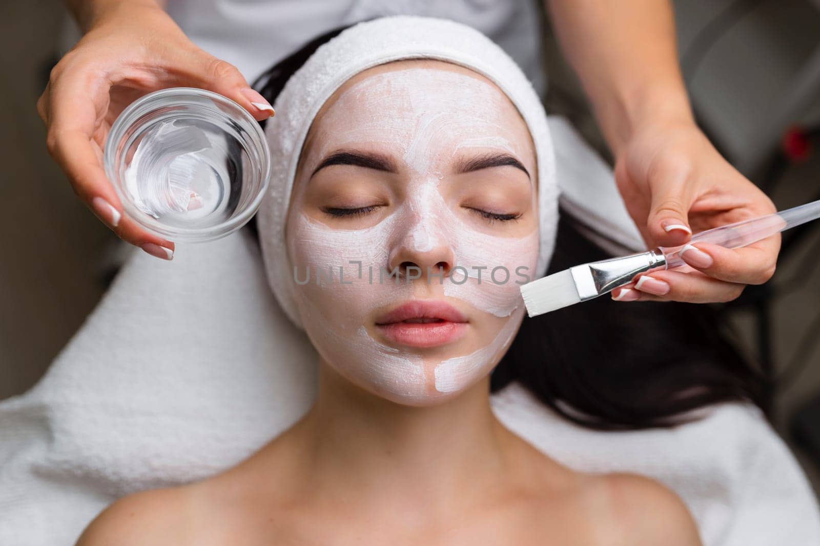 Close-up shot of a woman getting facial treatment with clay mask. Cosmetology and spa. High quality 4k footage