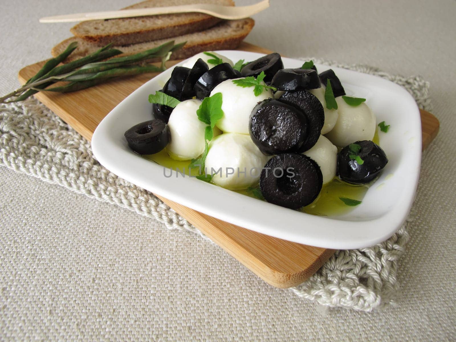 Marinated mozzarella with black olives,olive oil and leaf mustard