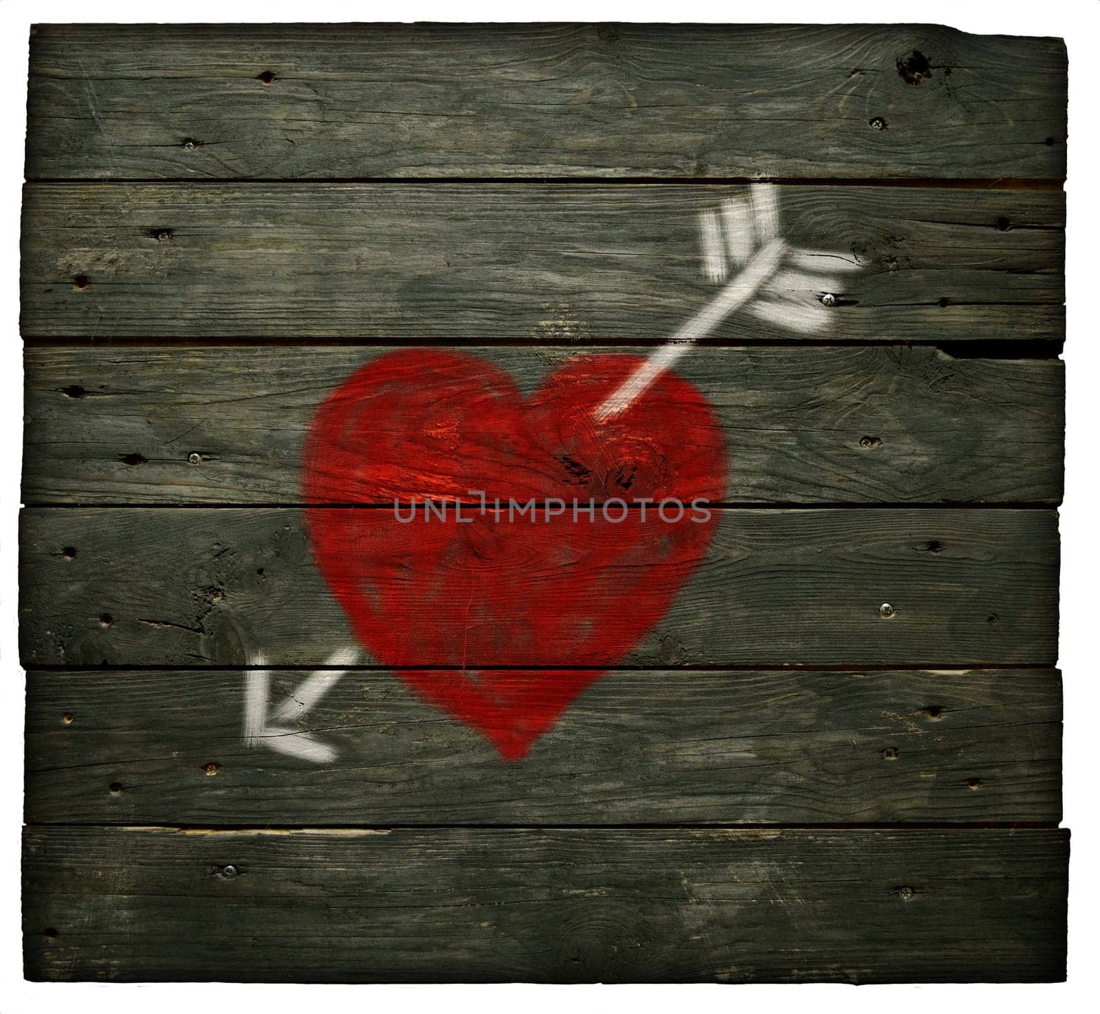painted heart with arrow on old board wall