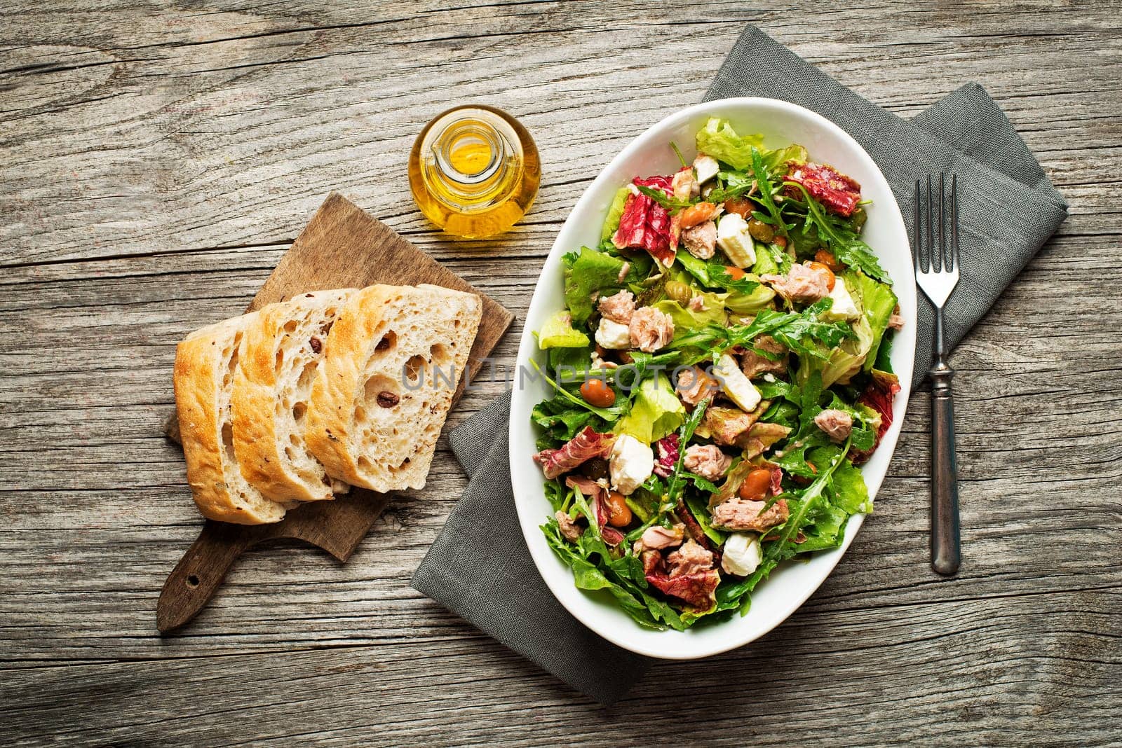 Tuna salad with lettuce, beans and cheese on wooden table