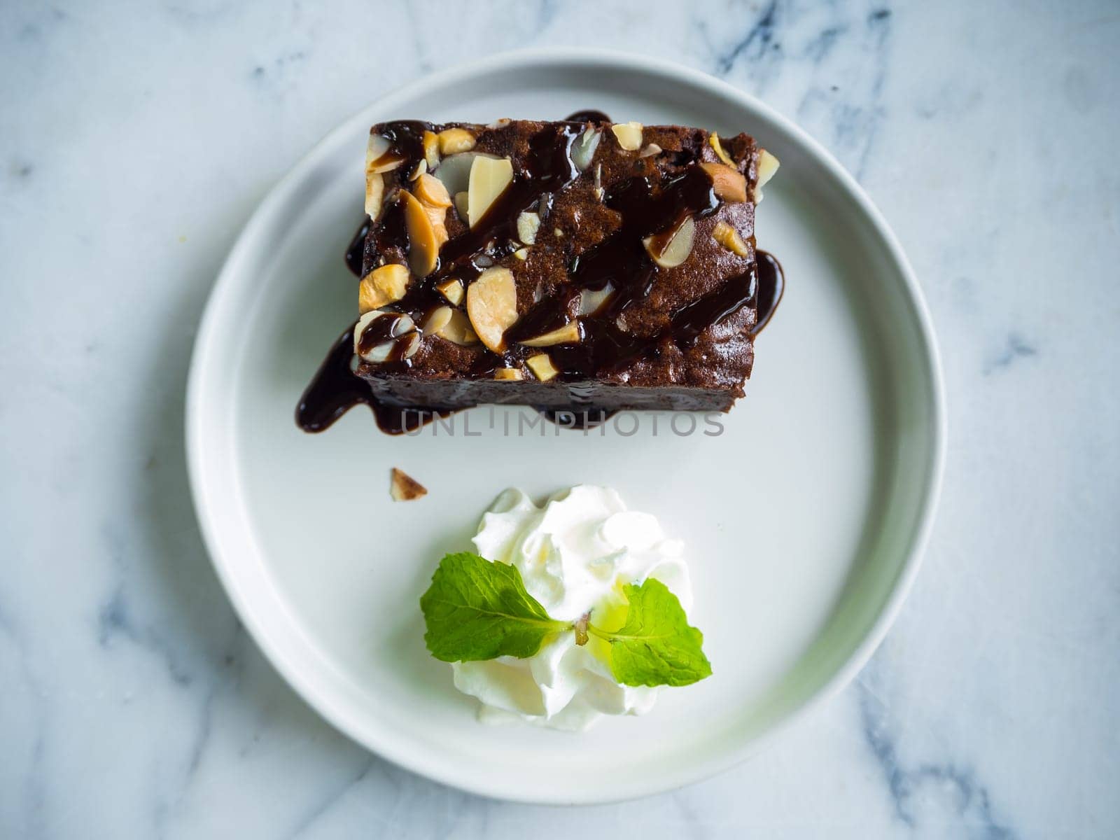 Close up sliced brownies on white plate with fork