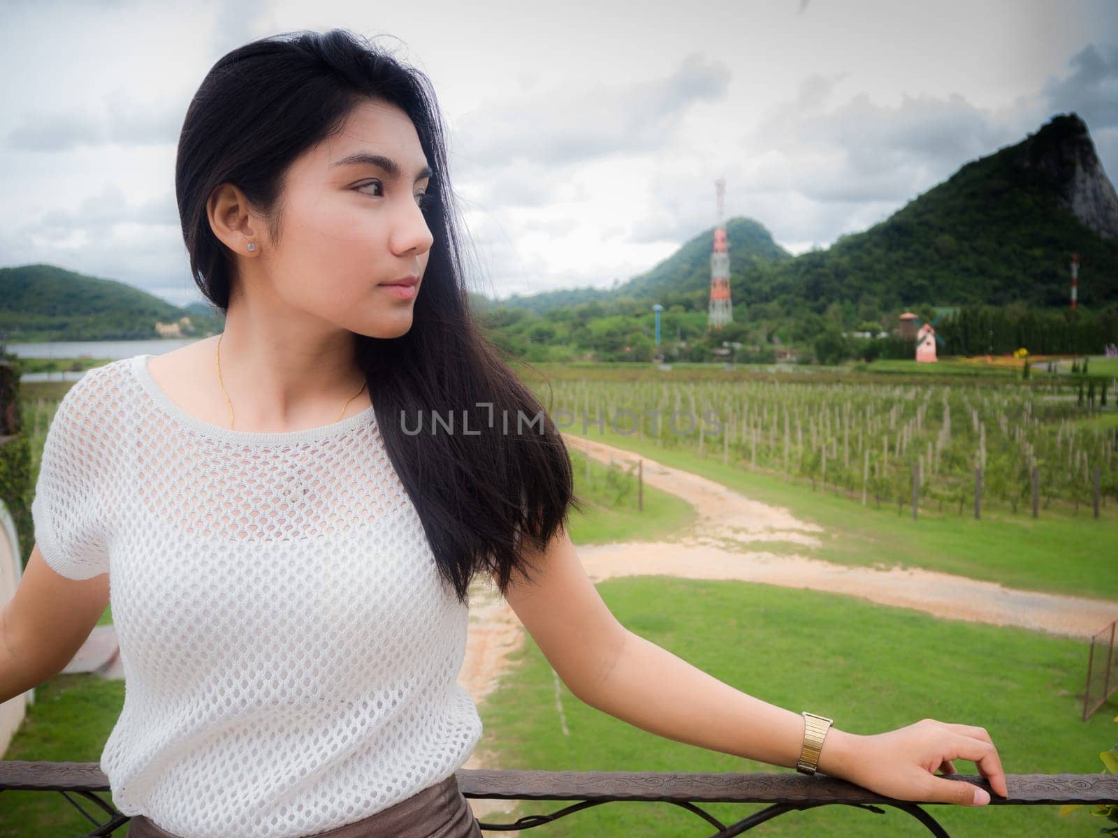A portrait of a beautiful asian woman in the white shirt standing on the balcony