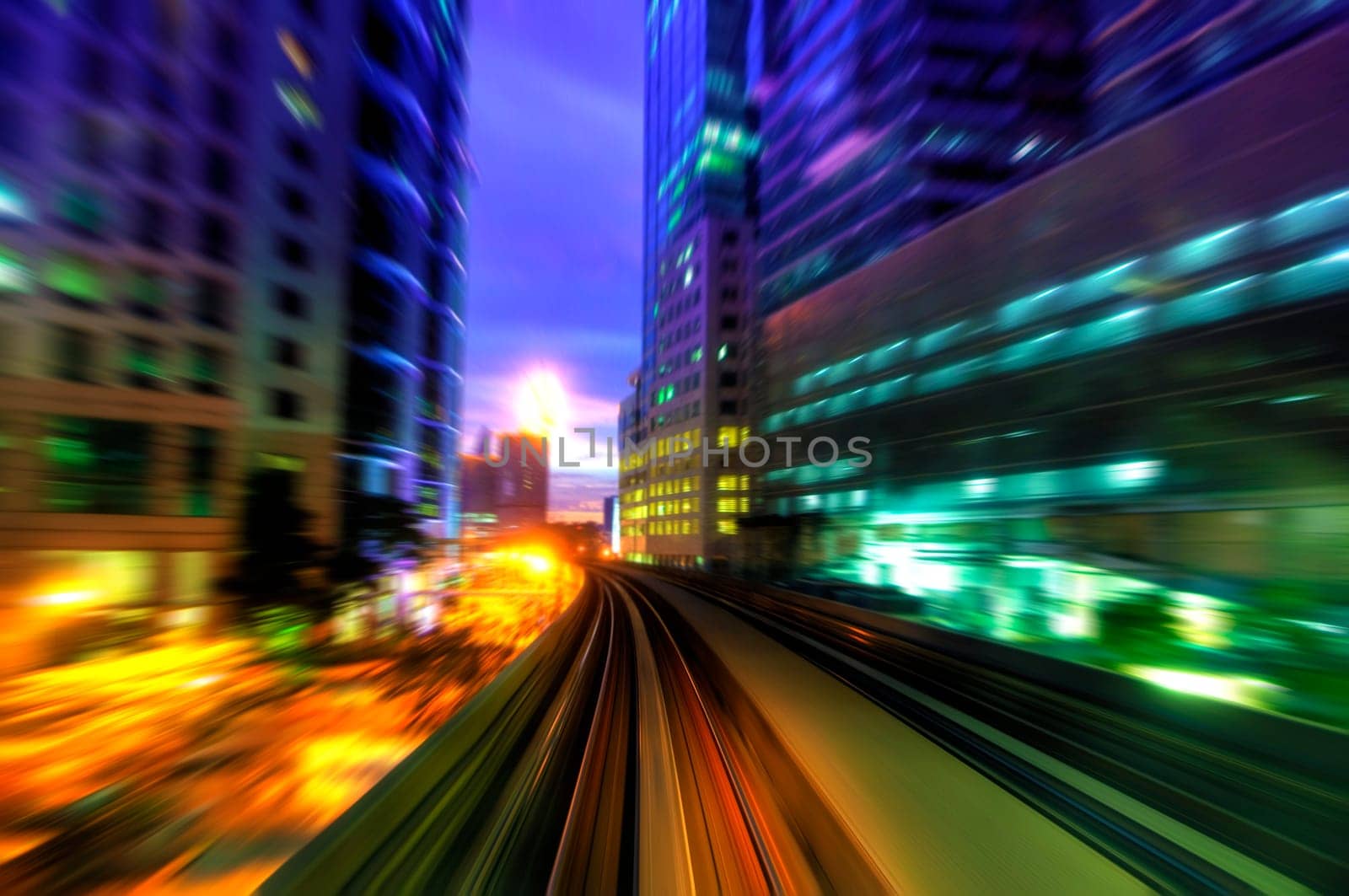 High speed train passing in between Kuala Lumpur City during dusk hour.