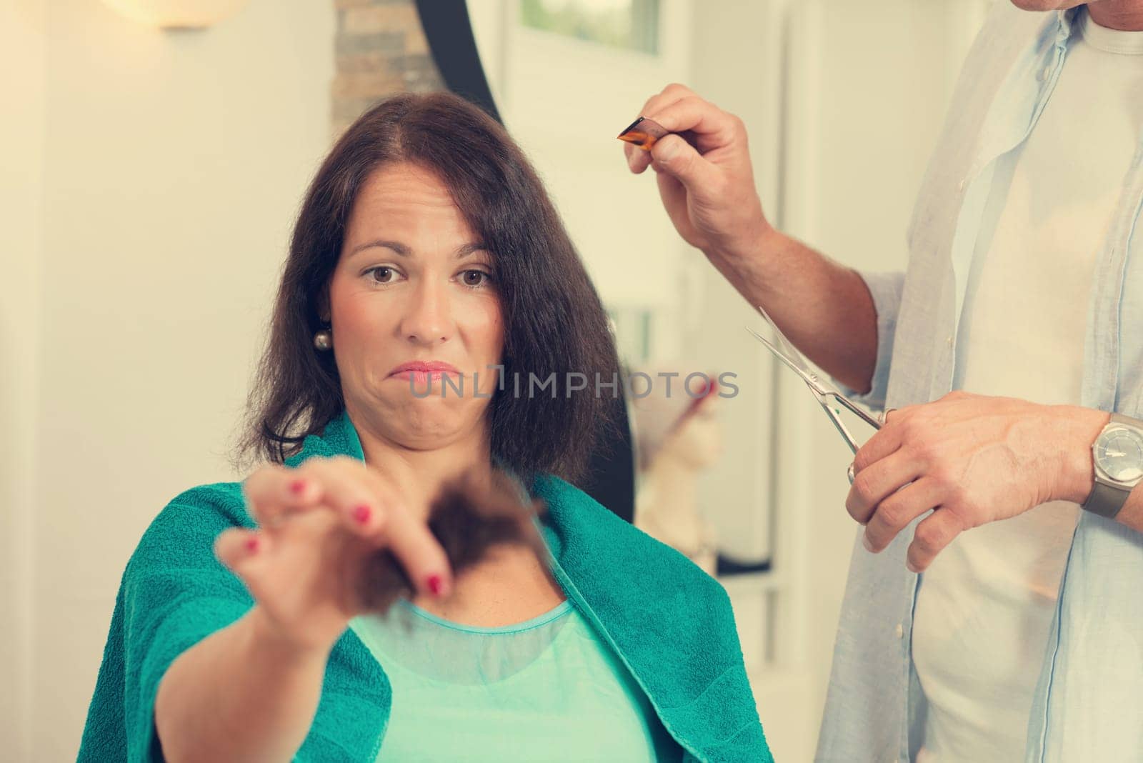 hairdresser cutting hair of woman in his shop