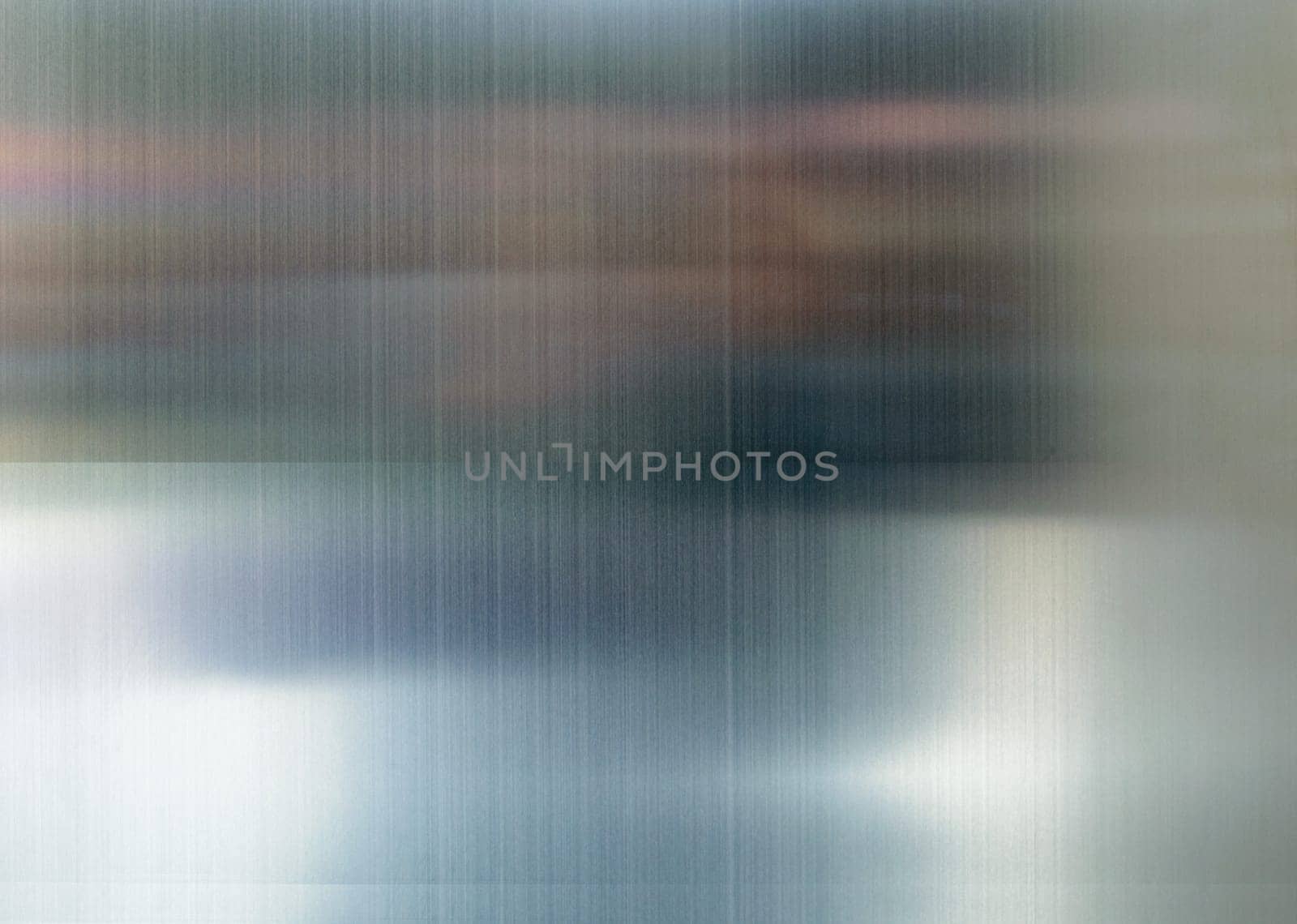 Convex polished shiny steel metal surface with multicolored reflections and glare.