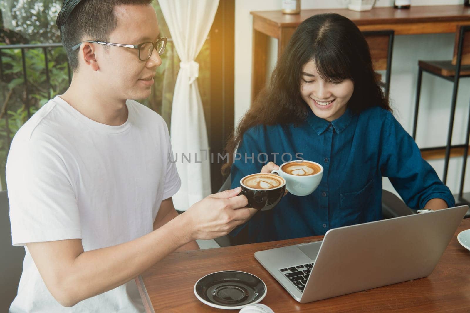 Business online concept. Asian friends meeting, drinking and having fun at coffee shop.