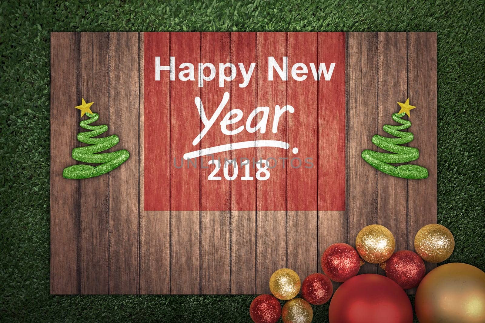 Christmas decoration with message of Happy New Year 2018 on wooden board on the grass