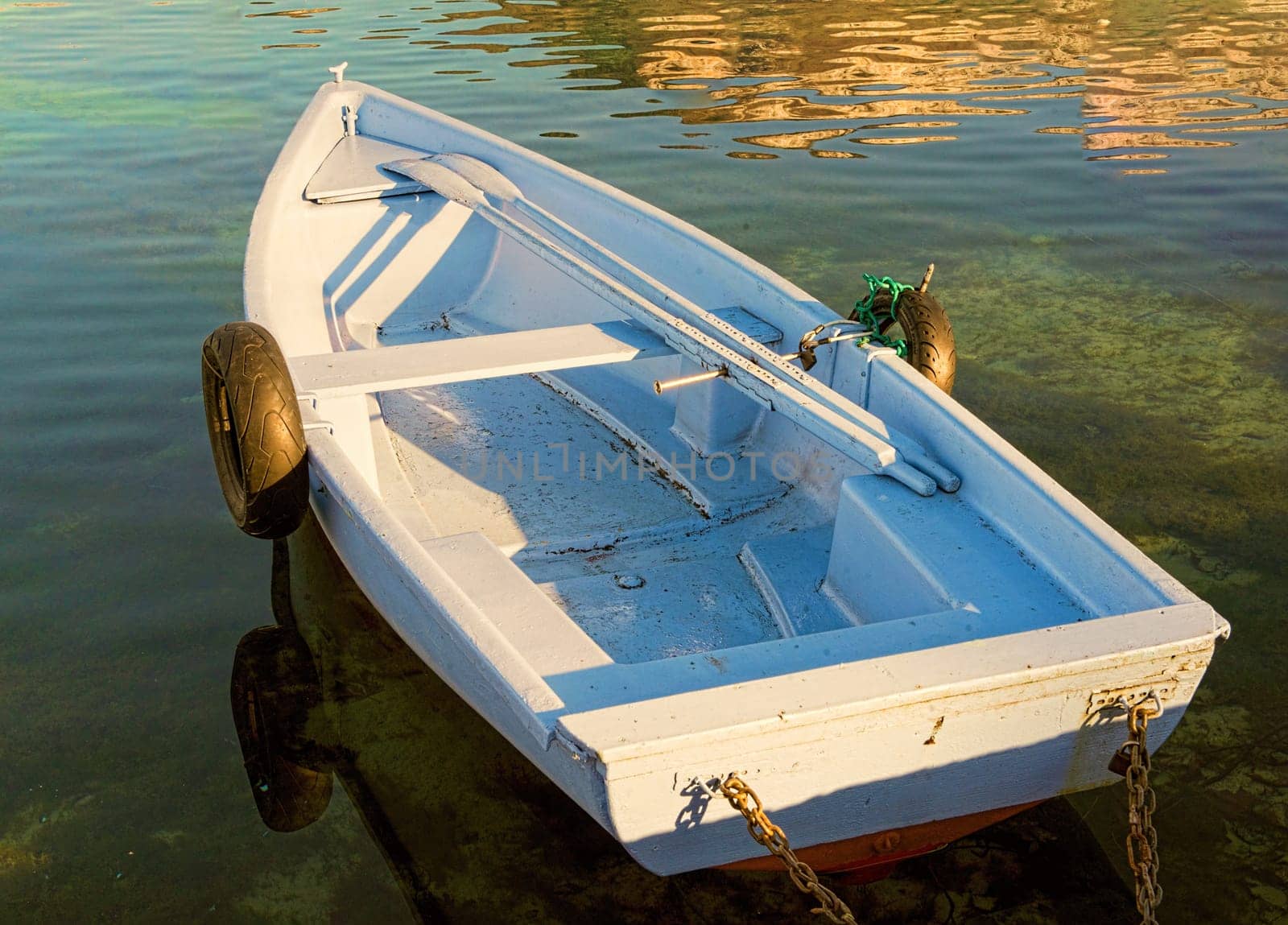 small rowing boat with two old tires