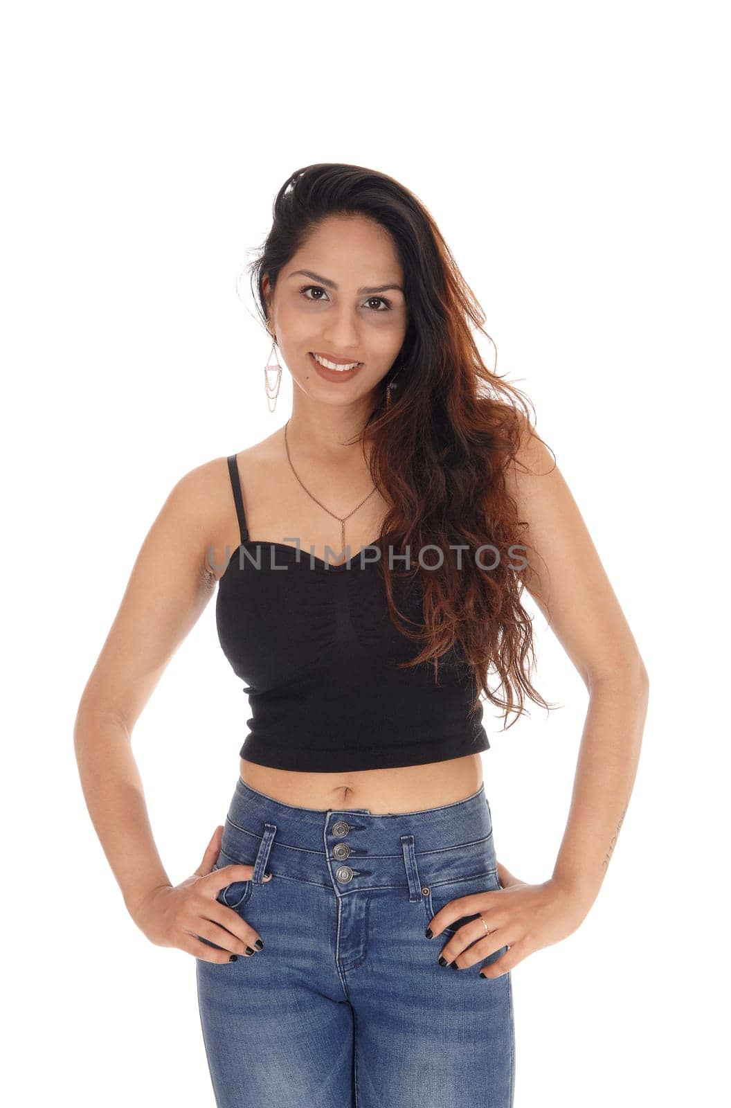 A beautiful young woman standing in jeans and a black corset with.brunette hair, isolated for white background.